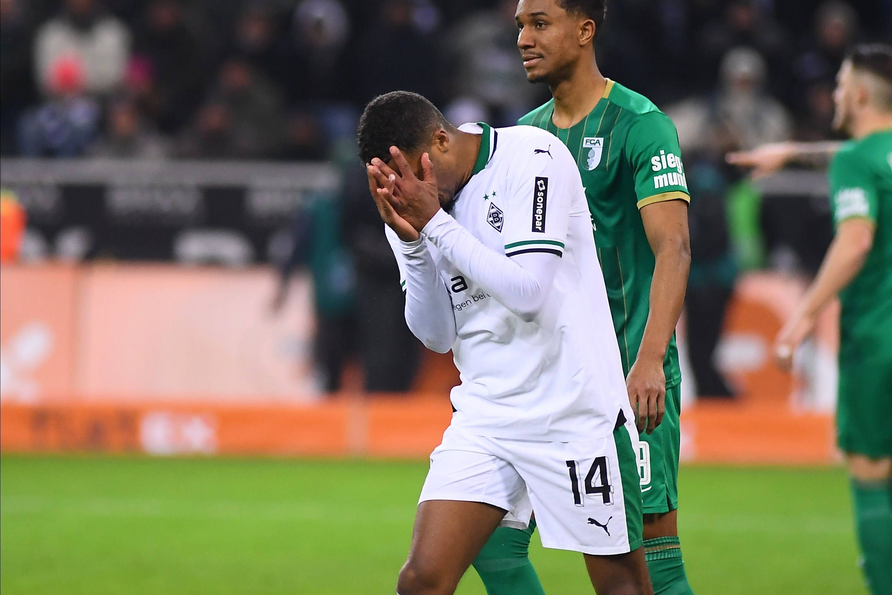 Alassane Plea vergräbt sein Gesicht in seinen Händen.