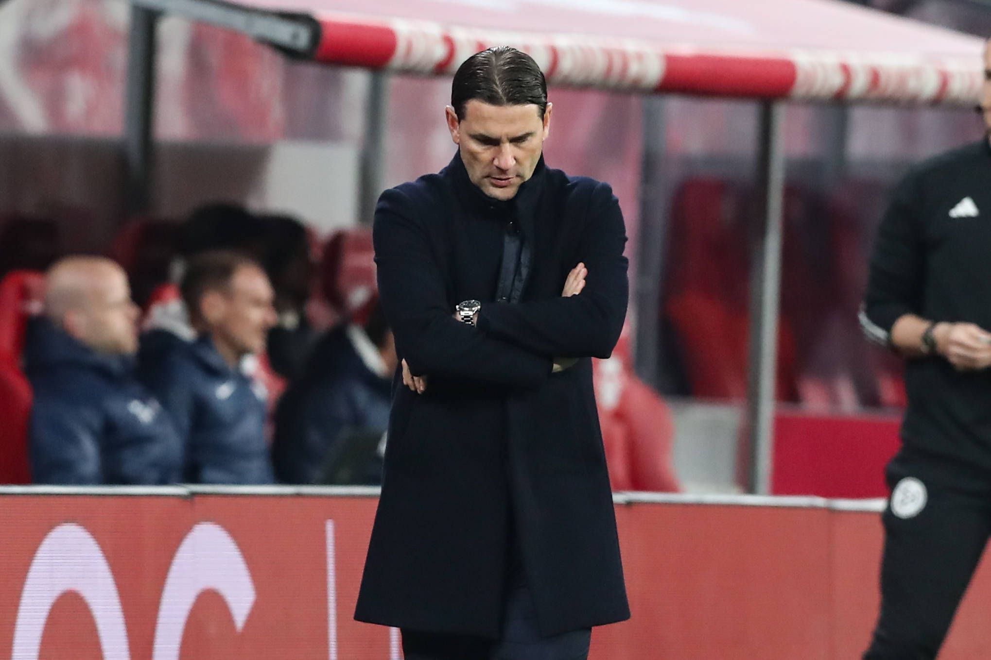 Trainer von Borussia Mönchengladbach verschränkt die Arme und schaut auf den Boden.