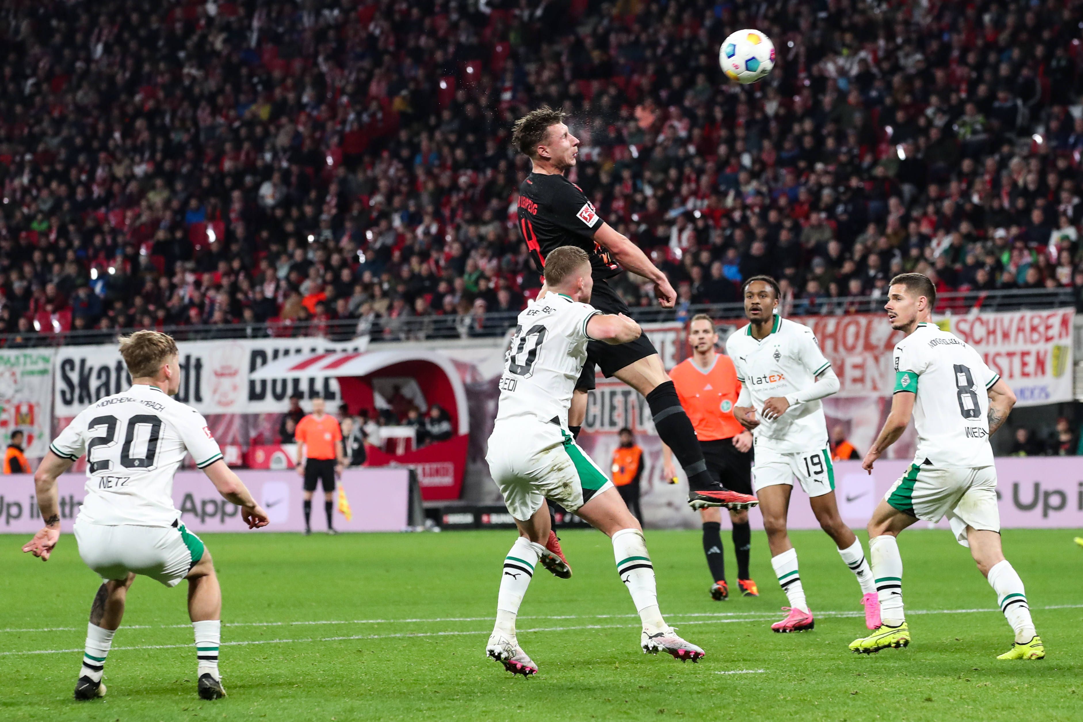 Spieler von Borussia Mönchengladbach bei dem Verteidigungsversuch einer Flanke.