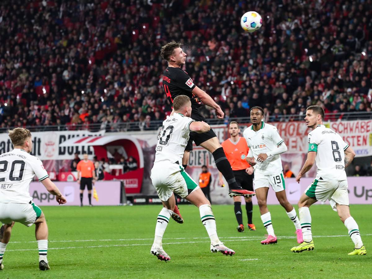 Spieler von Borussia Mönchengladbach bei dem Verteidigungsversuch einer Flanke.