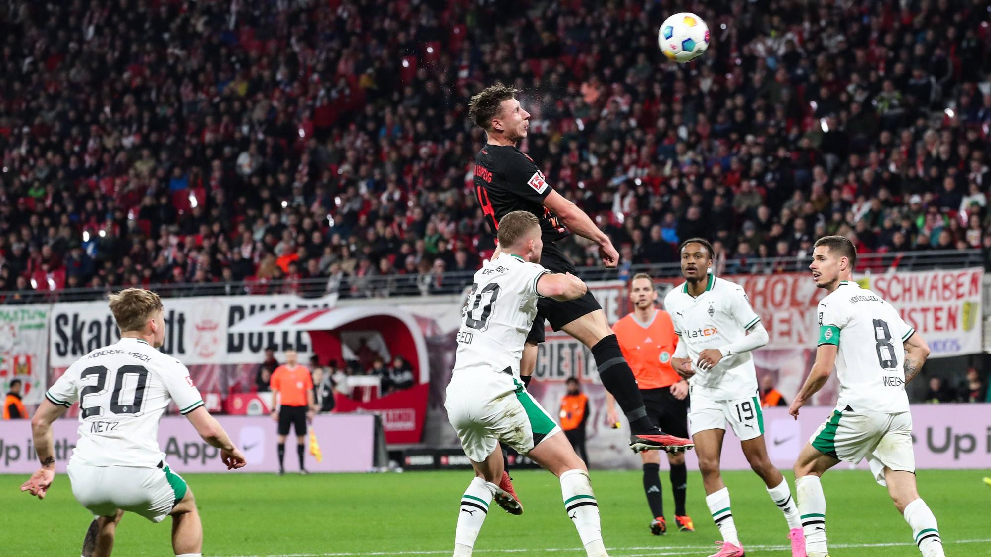 Spieler von Borussia Mönchengladbach bei dem Verteidigungsversuch einer Flanke.