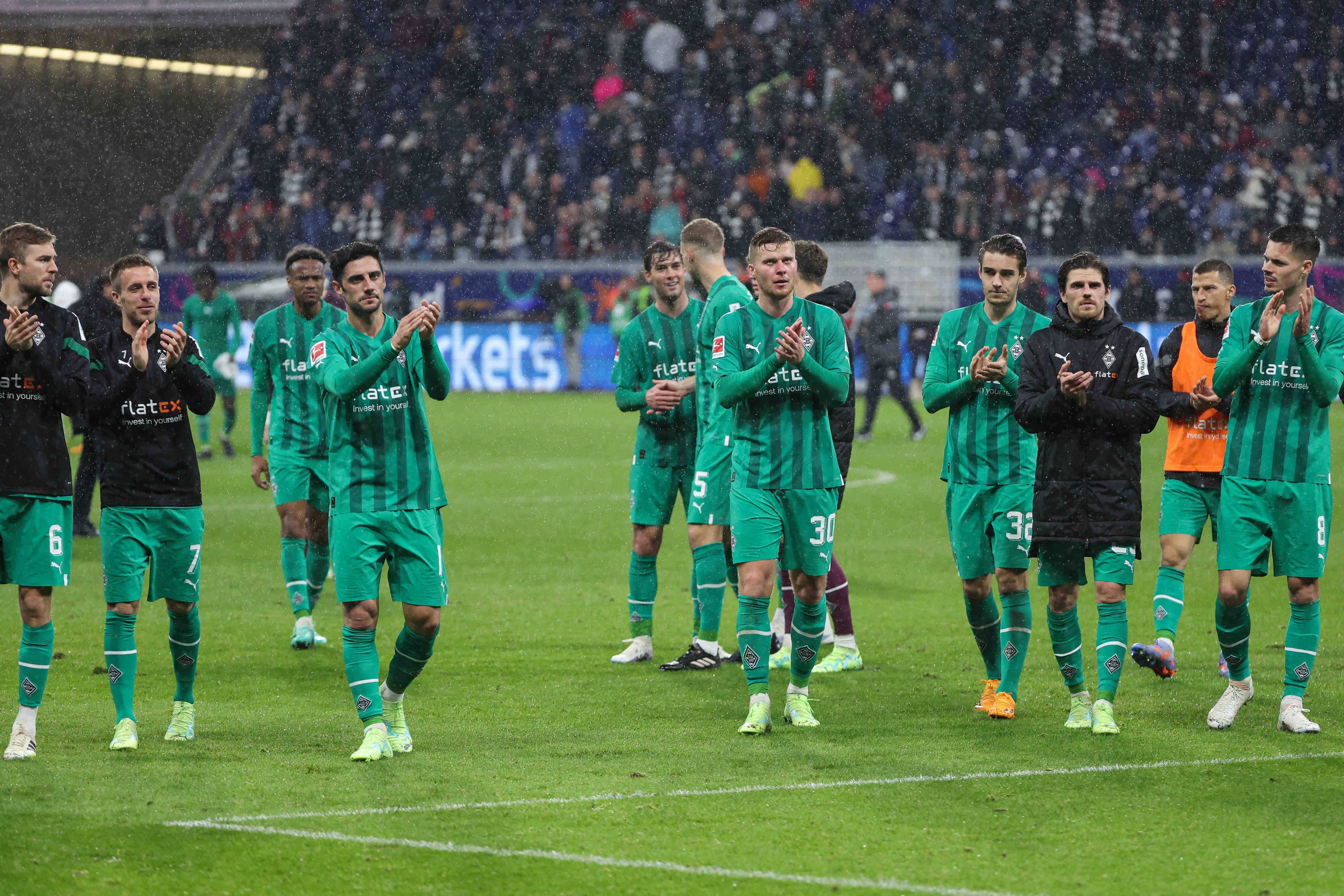Spieler von Borussia Mönchengladbach stehen klatschend vor den Fans.