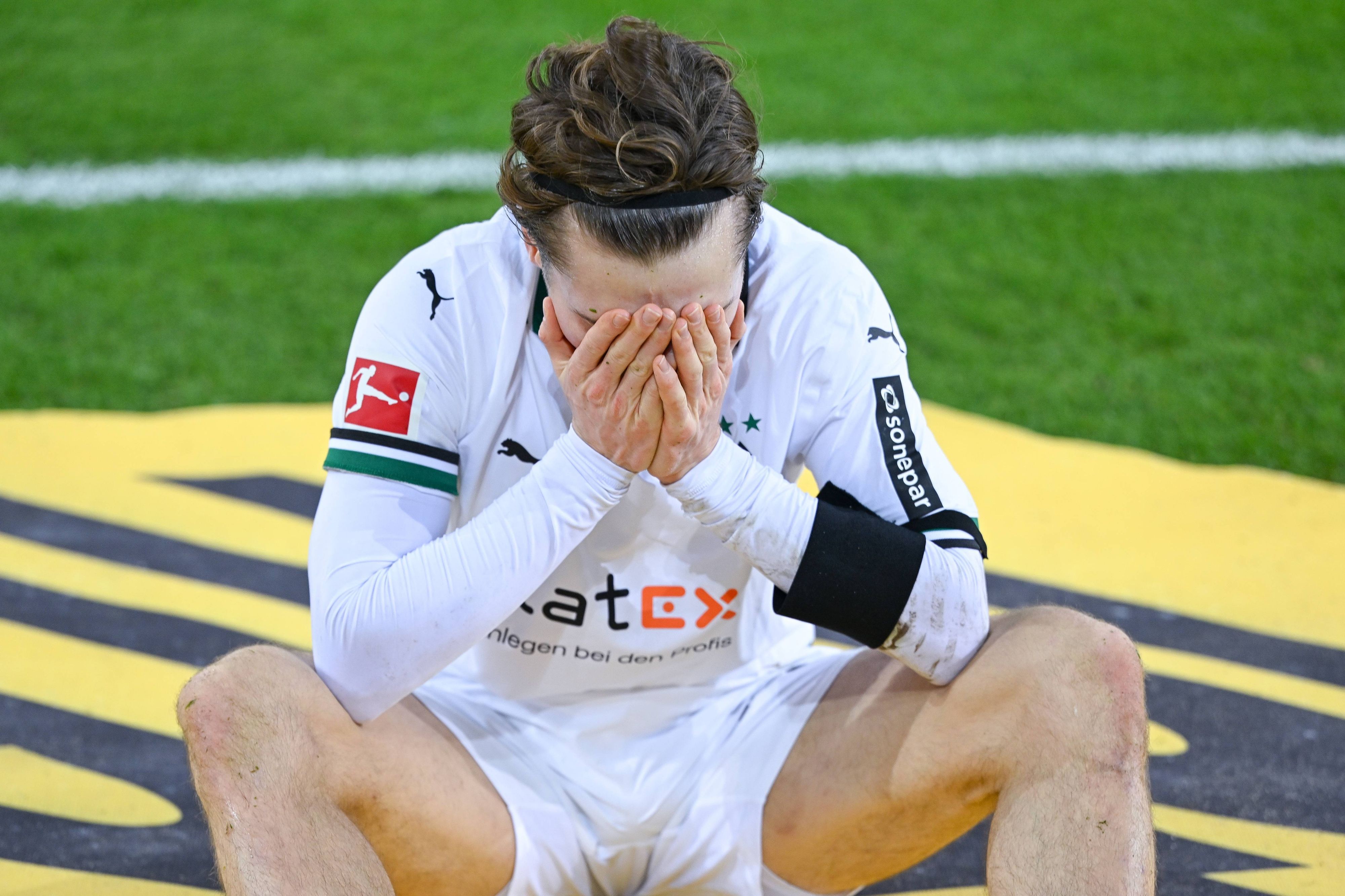 Rocco Reitz hält sich die Hand vor das Gesicht.