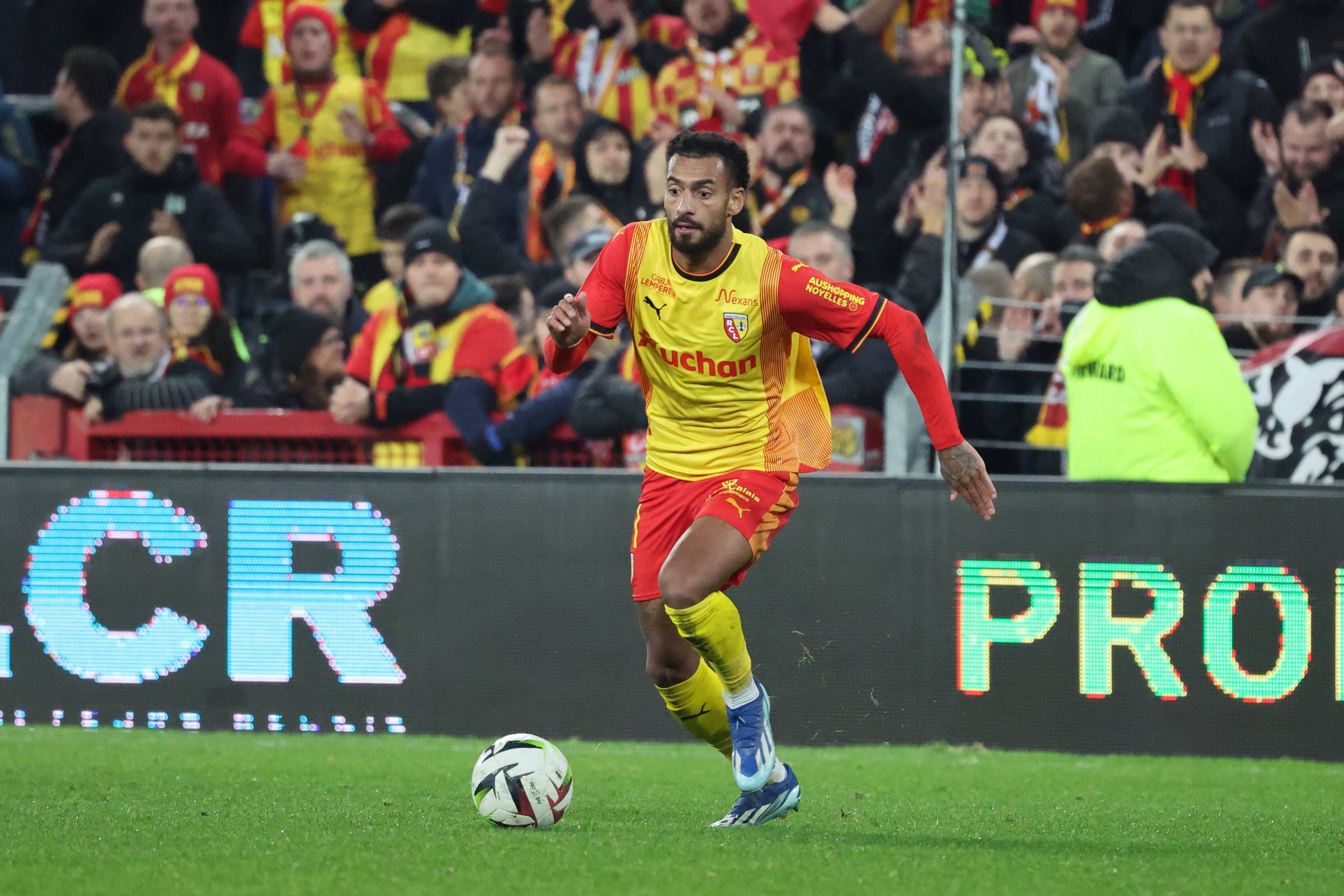 Angelo Fulgini dribbelt mit dem Ball im gelben Lens-Trikot.