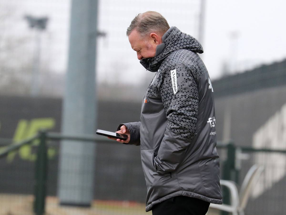 Roland Virkus schaut auf sein Smartphone.