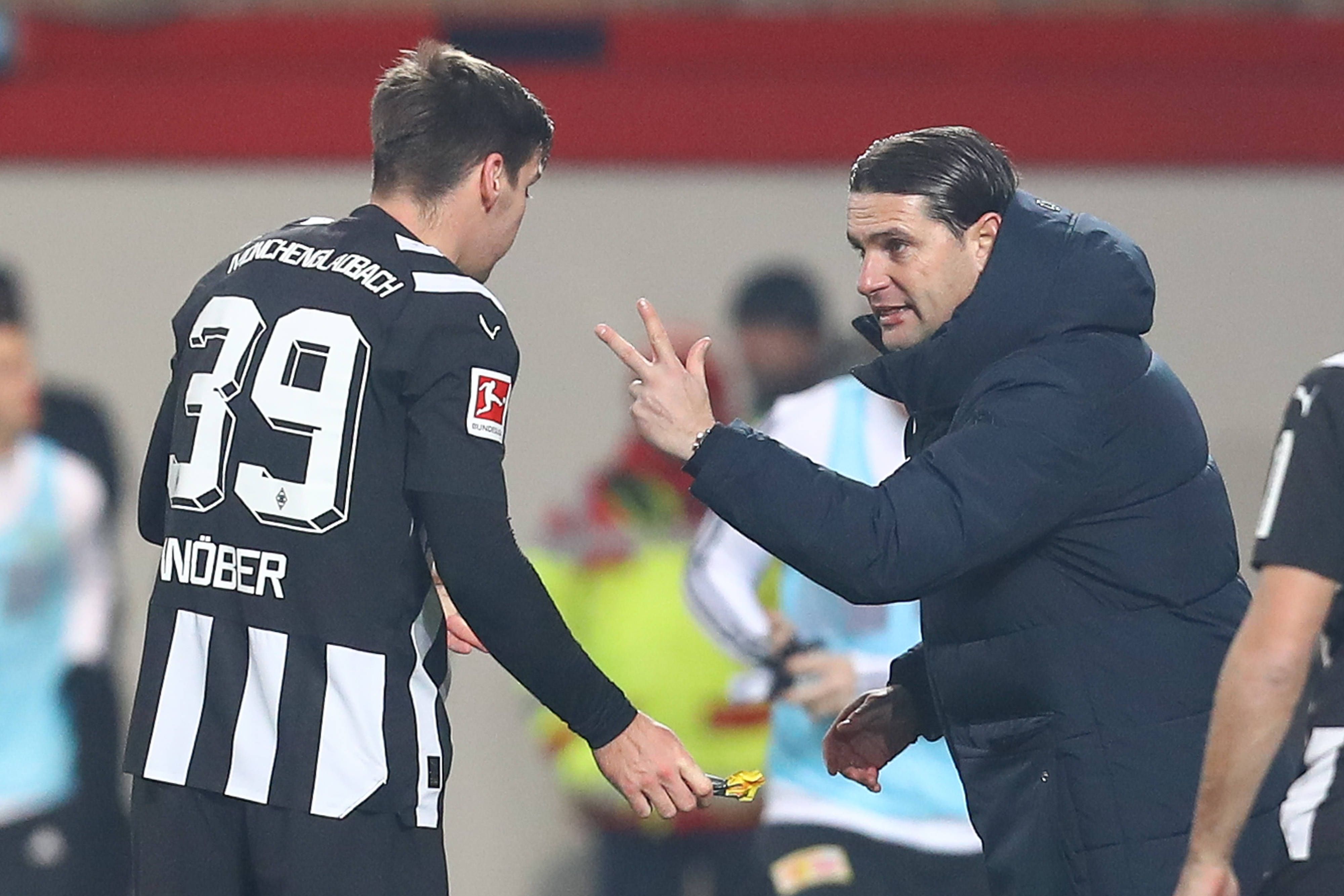 Gerardo Seoane hält Maximilian Wöber im schwarz-weißen Ausweichtrikot drei Finger vor das Gesicht.
