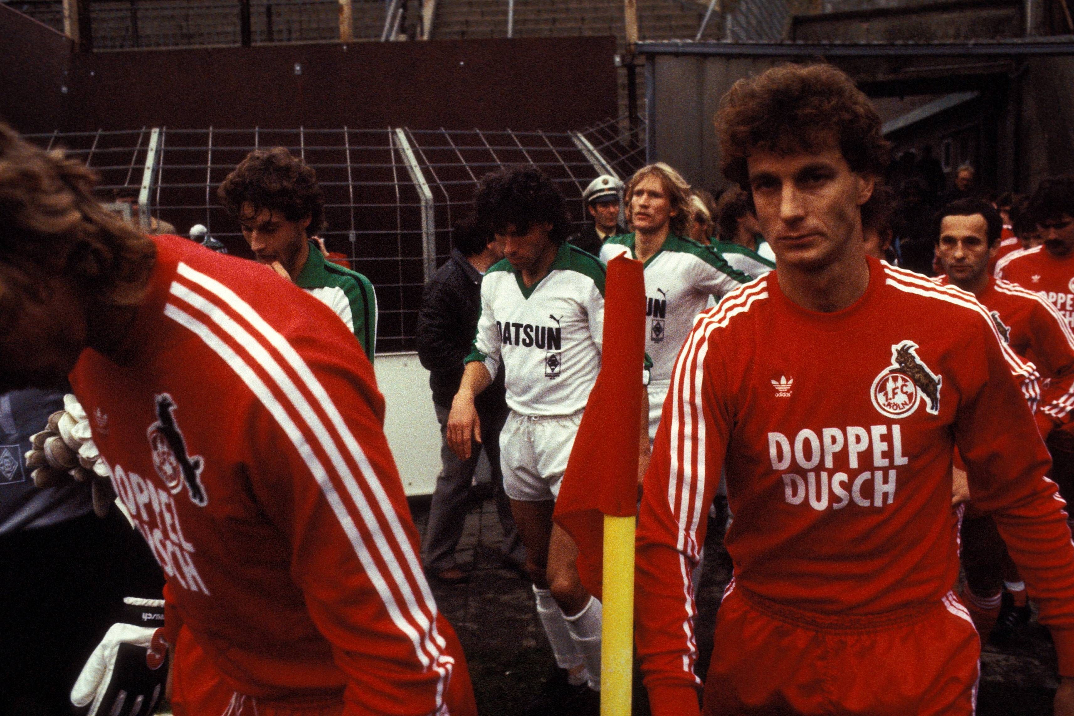 Rainer Bonhof und weitere Spieler des 1. FC Köln und von Borussia Mönchengladbach betreten den Bökelberg-Rasen.