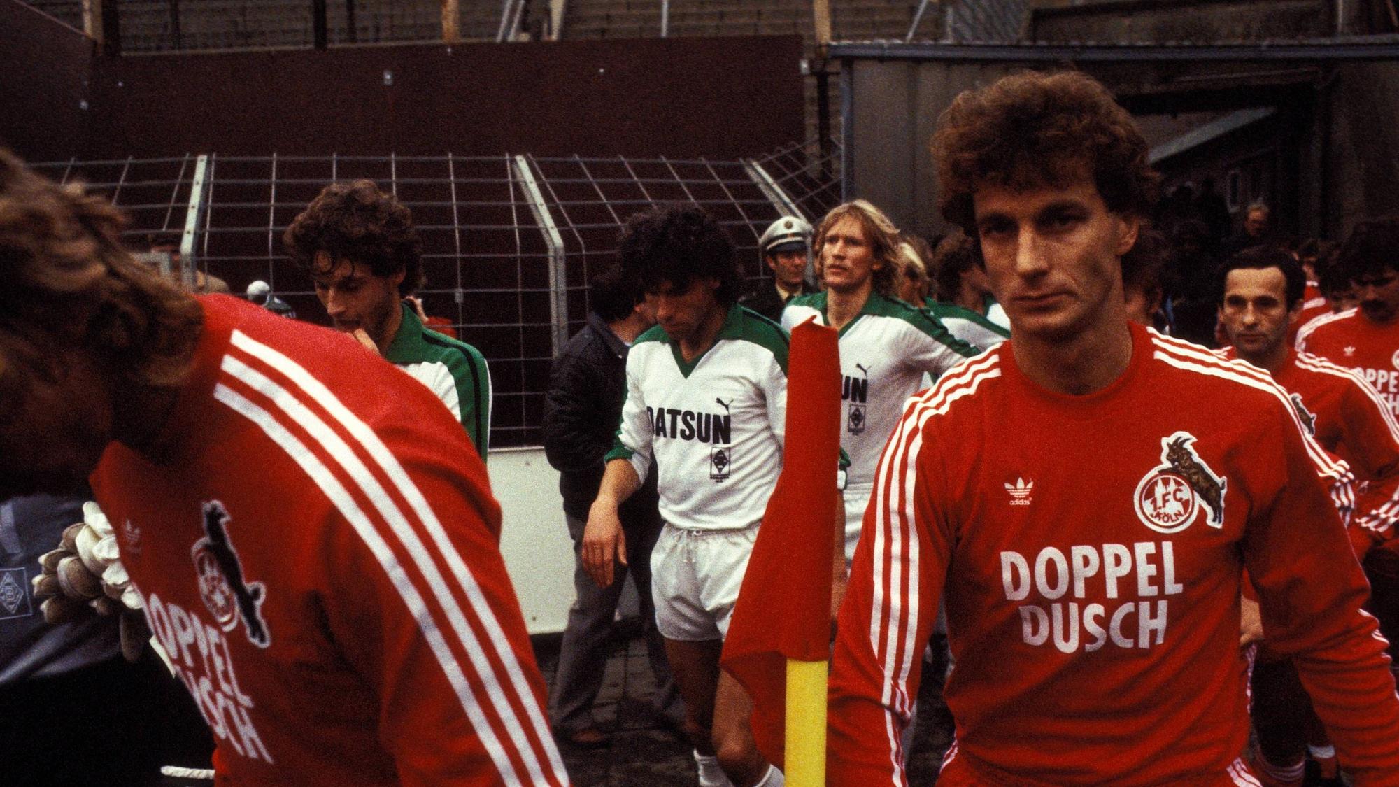 Rainer Bonhof und weitere Spieler des 1. FC Köln und von Borussia Mönchengladbach betreten den Bökelberg-Rasen.