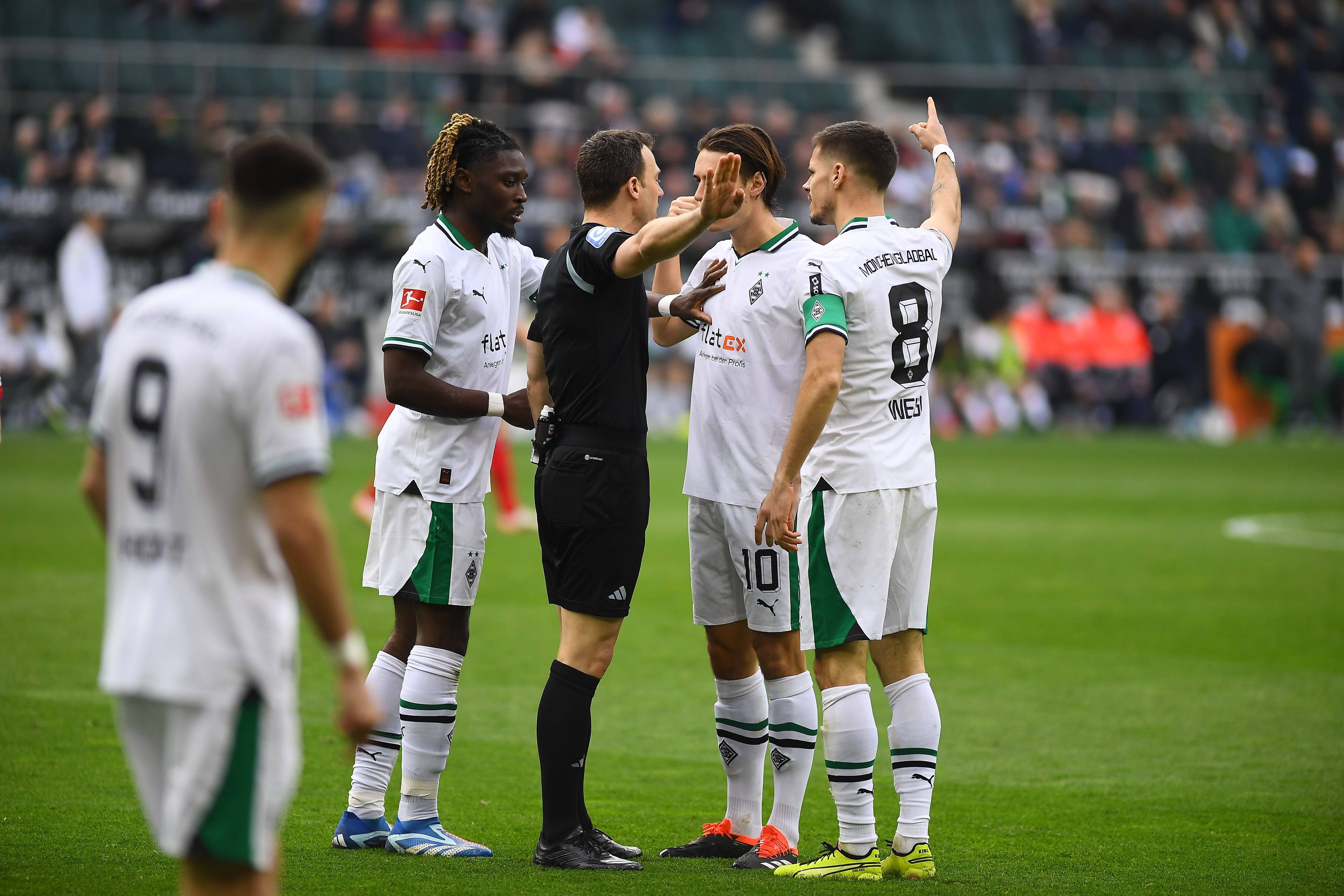 Felix Zwayer umringt von Borussia-Spielern.