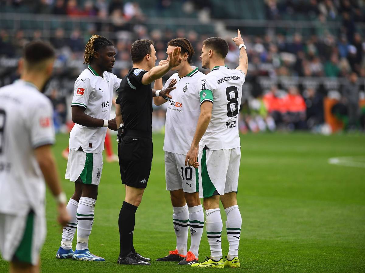 Felix Zwayer umringt von Borussia-Spielern.