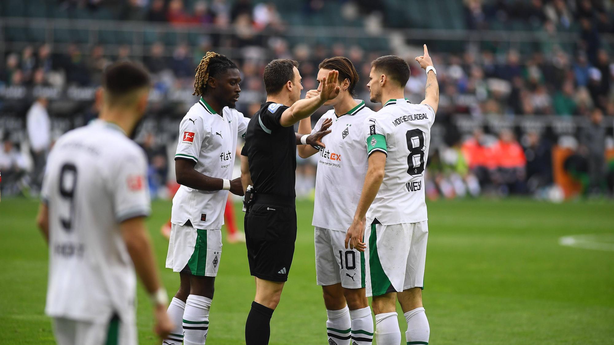 Felix Zwayer umringt von Borussia-Spielern.