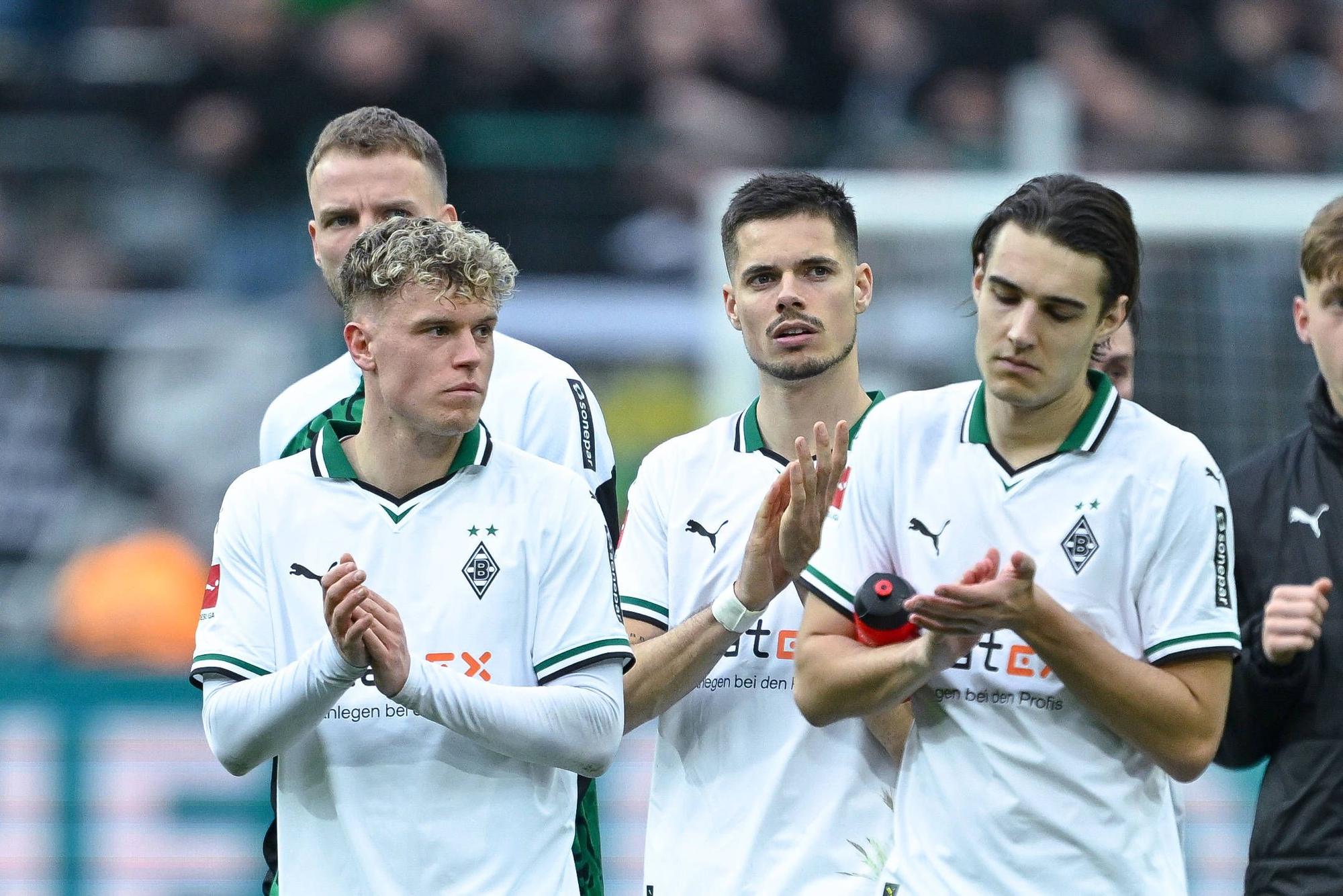 Robin Hack, Julian Weigl und Florian Neuhaus applaudieren ihren Fans mit enttäuschten Blicken.