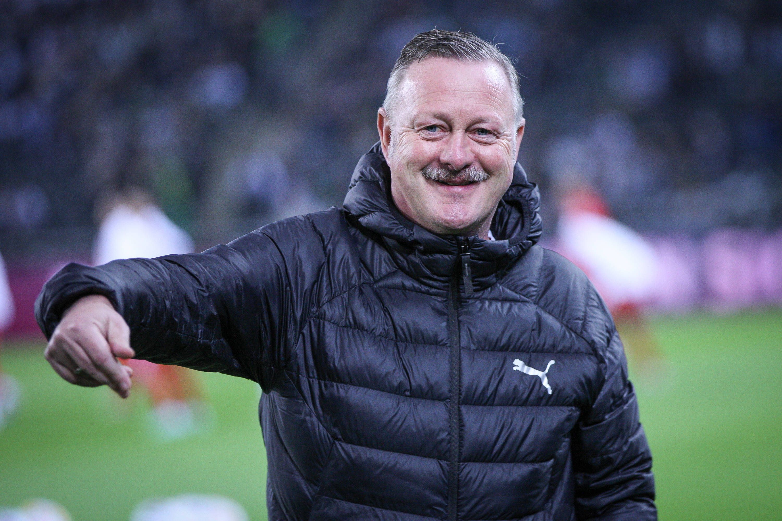 Roland Virkus grinst am Spielfeldrand.