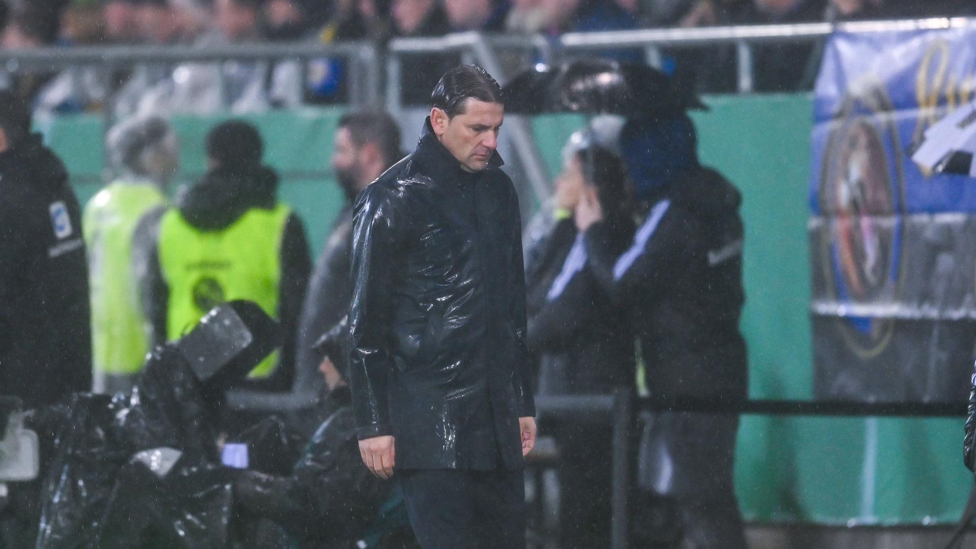 Trainer von Borussia Mönchengladbach in der Coaching-Zone, schaut auf den Boden.