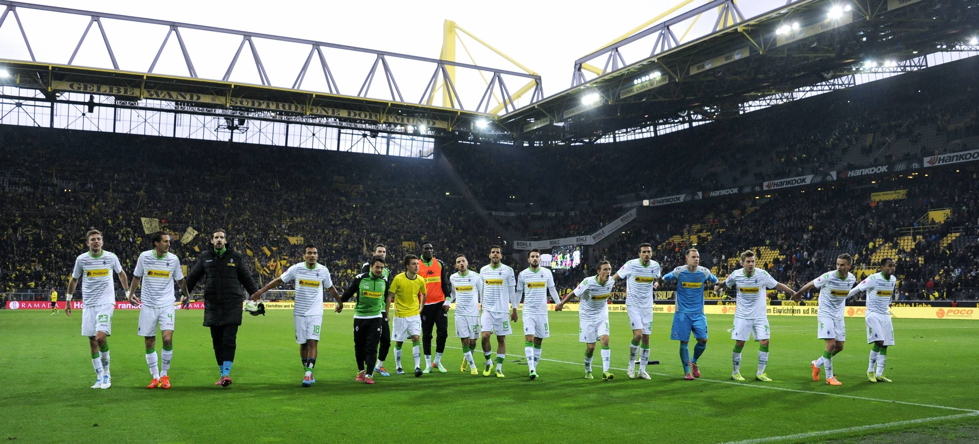 Spieler von Borussia Mönchengladbach feiern mit den Fans im Signal Iduna Park.