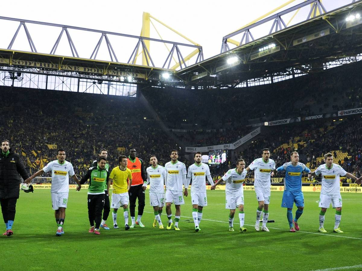 Spieler von Borussia Mönchengladbach feiern mit den Fans im Signal Iduna Park.
