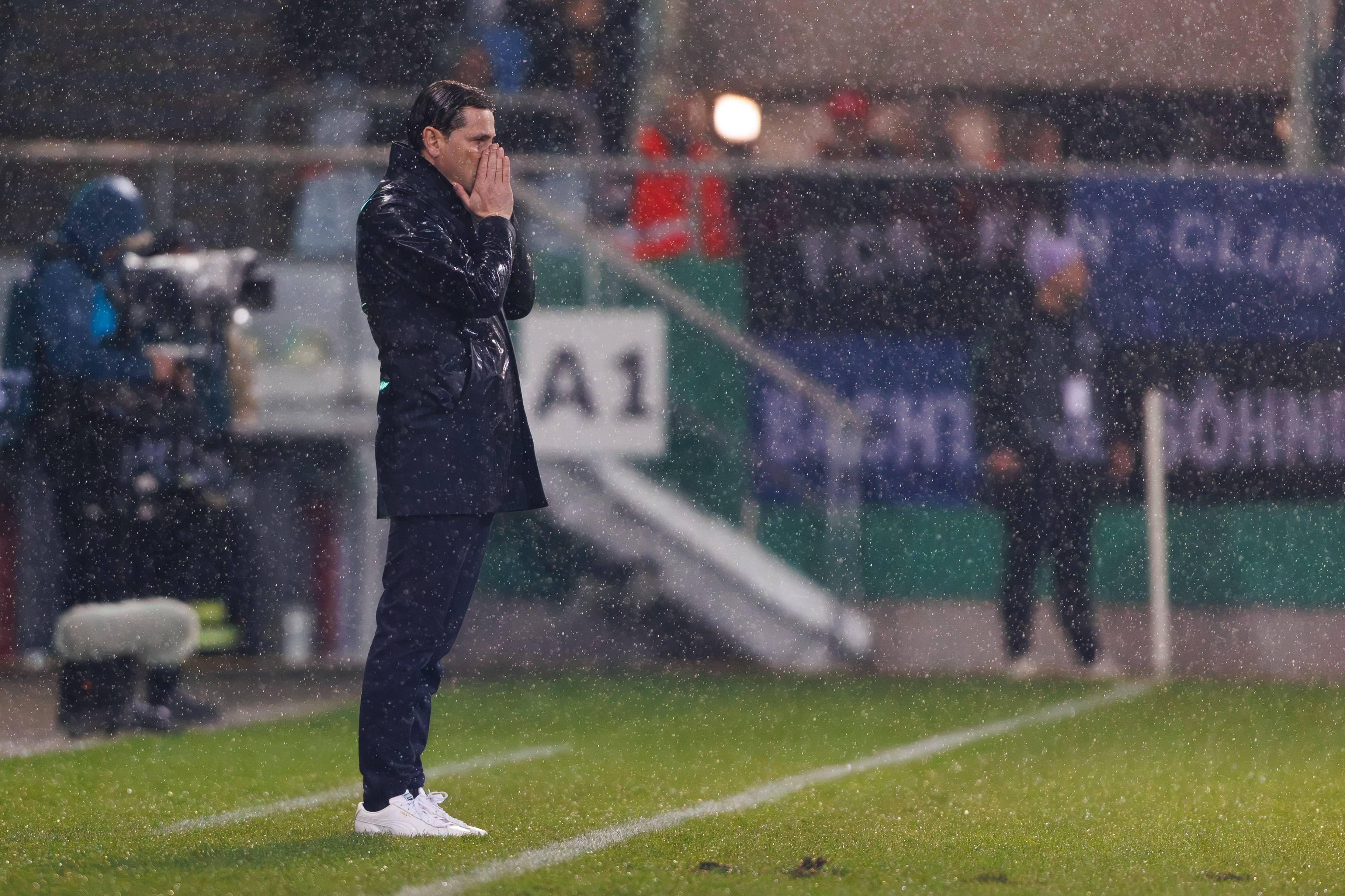 Gerardo Seoane steht im Regen und hält sich die Hände vor das Gesicht.