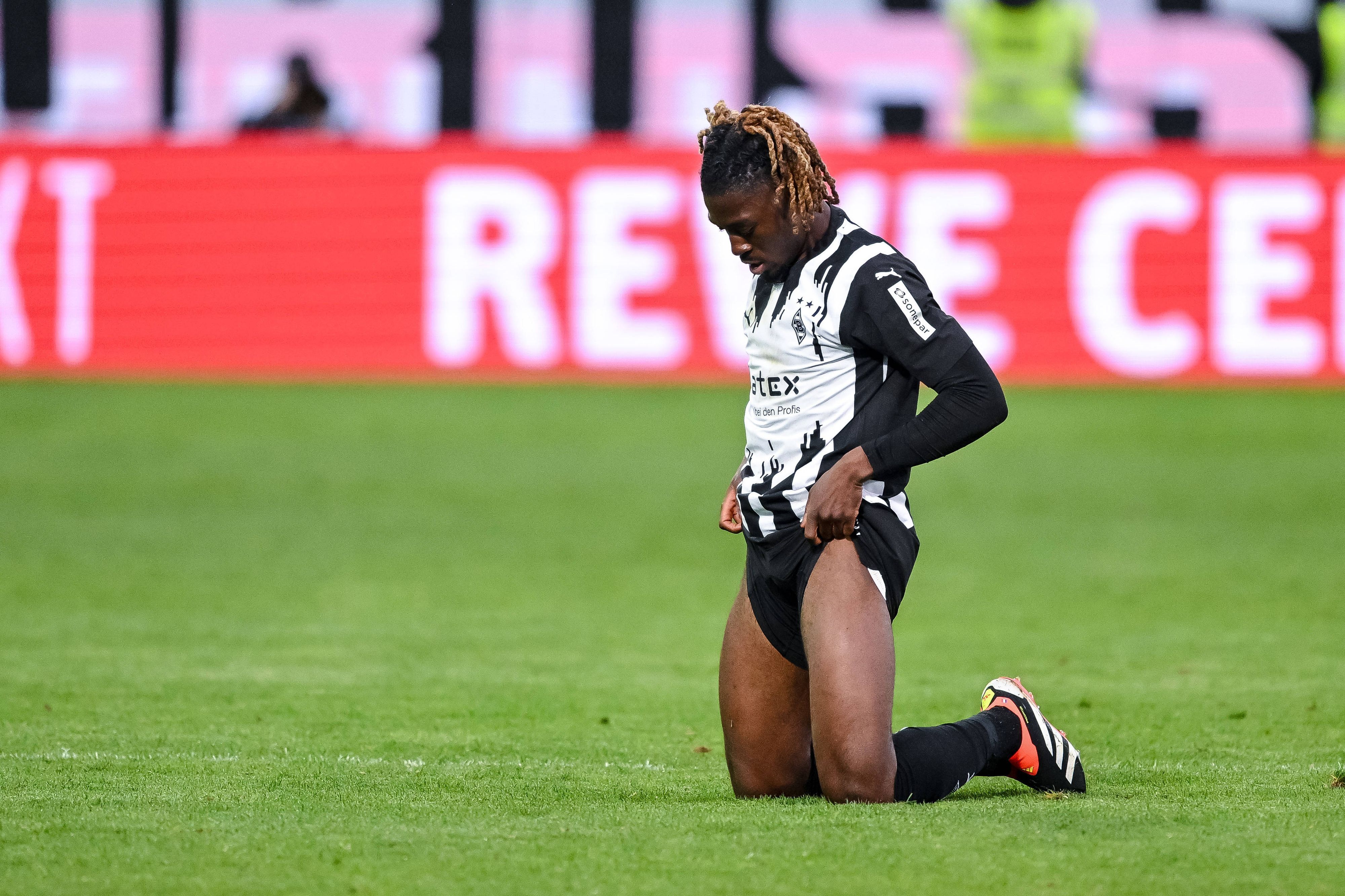 Manu Koné zieht sich die Hosenbeine hoch.