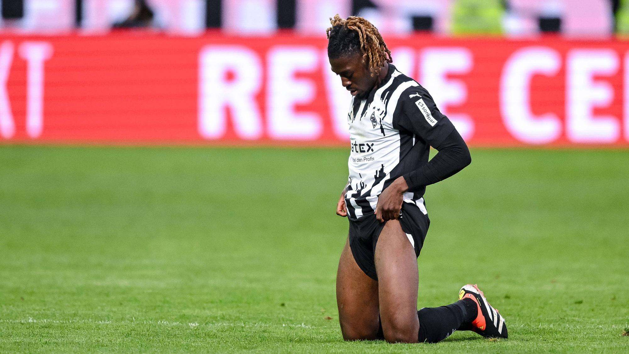 Manu Koné zieht sich die Hosenbeine hoch.
