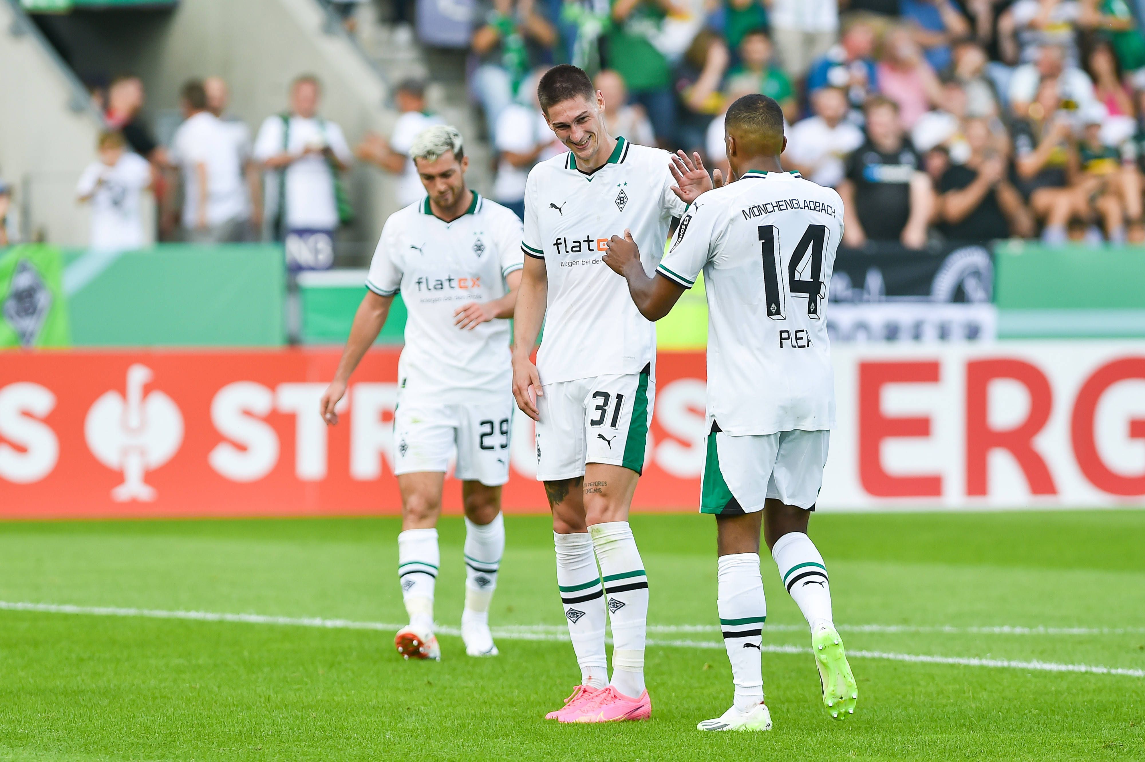 Zwei Spieler von Borussia Mönchengladbach klatschen sich gegenseitig ab.
