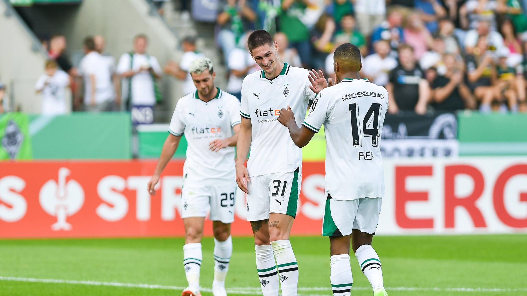 Zwei Spieler von Borussia Mönchengladbach klatschen sich gegenseitig ab.