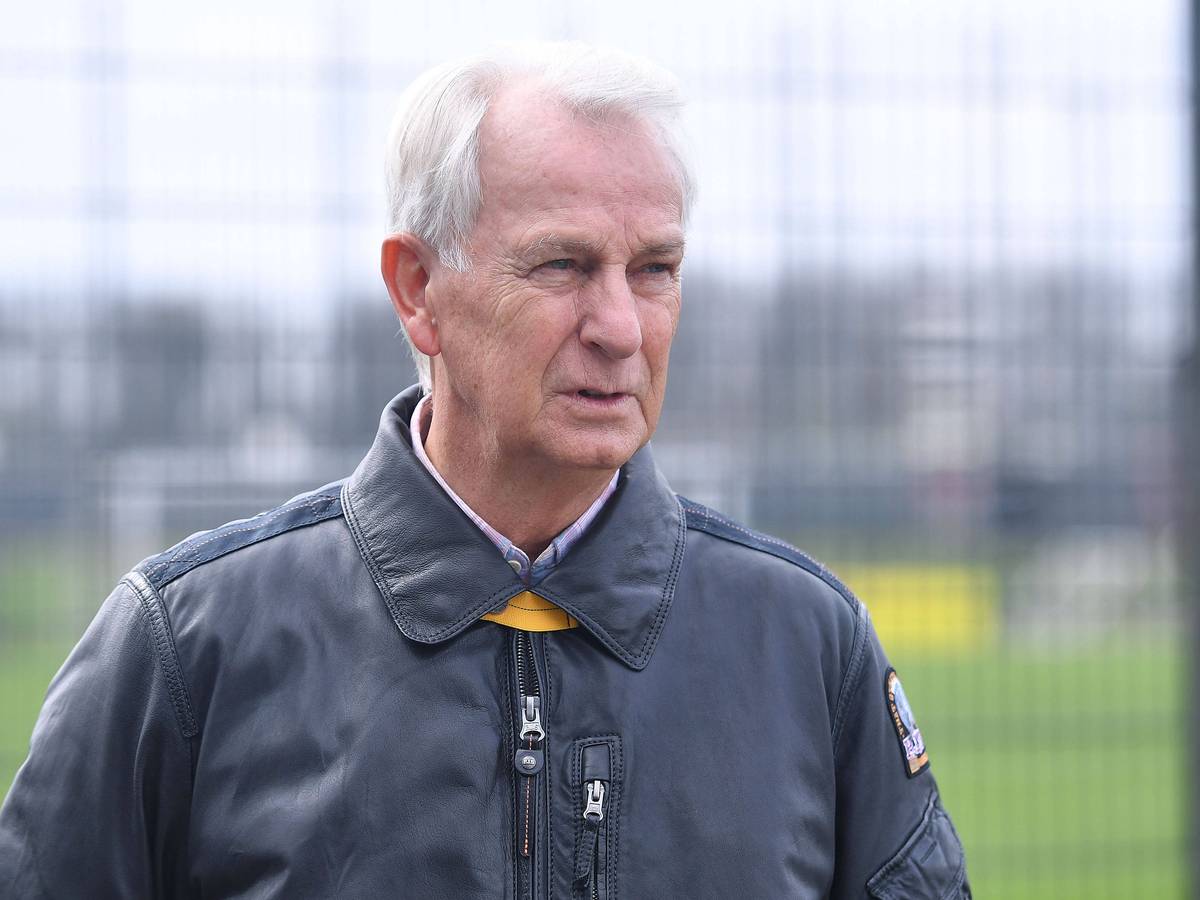 Rainer Bonhof mit fokussiertem Blick in einer Lederjacke am Trainingsplatz.