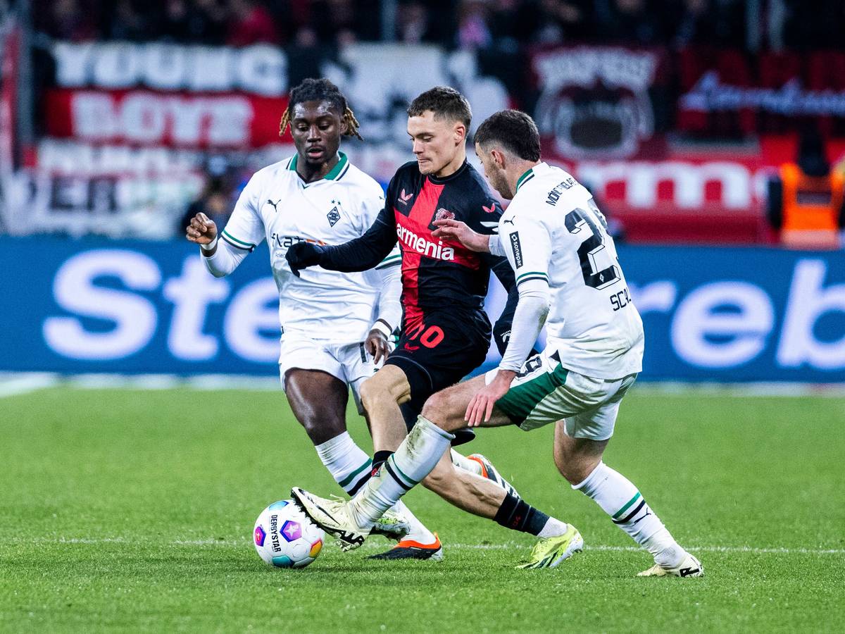 Florian Wirtz behauptet den Ball gegen zwei Spieler von Borussia Mönchengladbach.