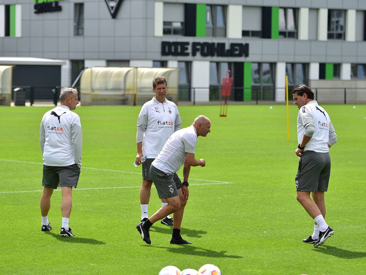 Vier Gladbach-Trainer auf dem Platz. Oliver Neuville greift sich ans Knie.