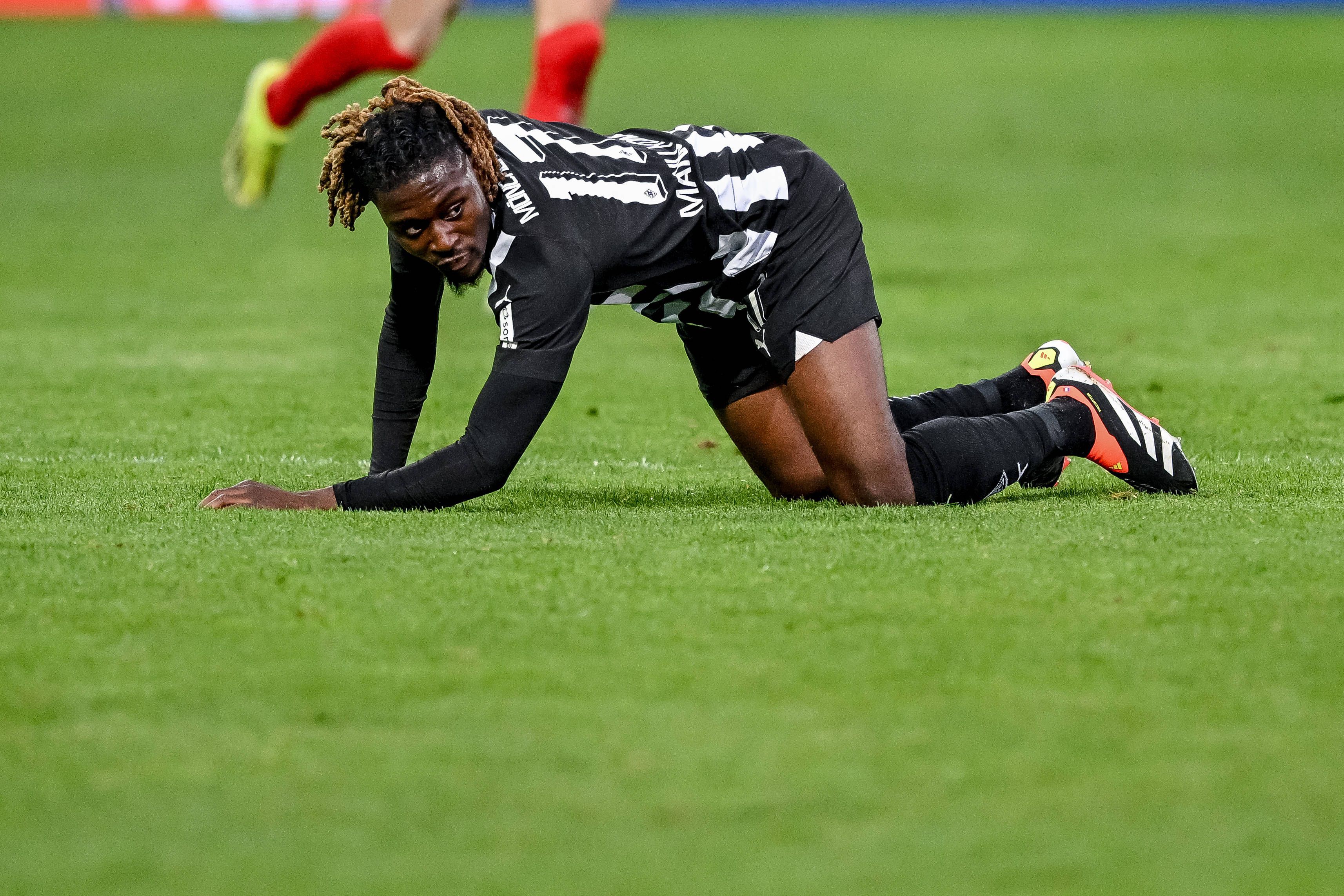 Manu Koné liegt im Spiel in Heidenheim auf dem Rasen.
