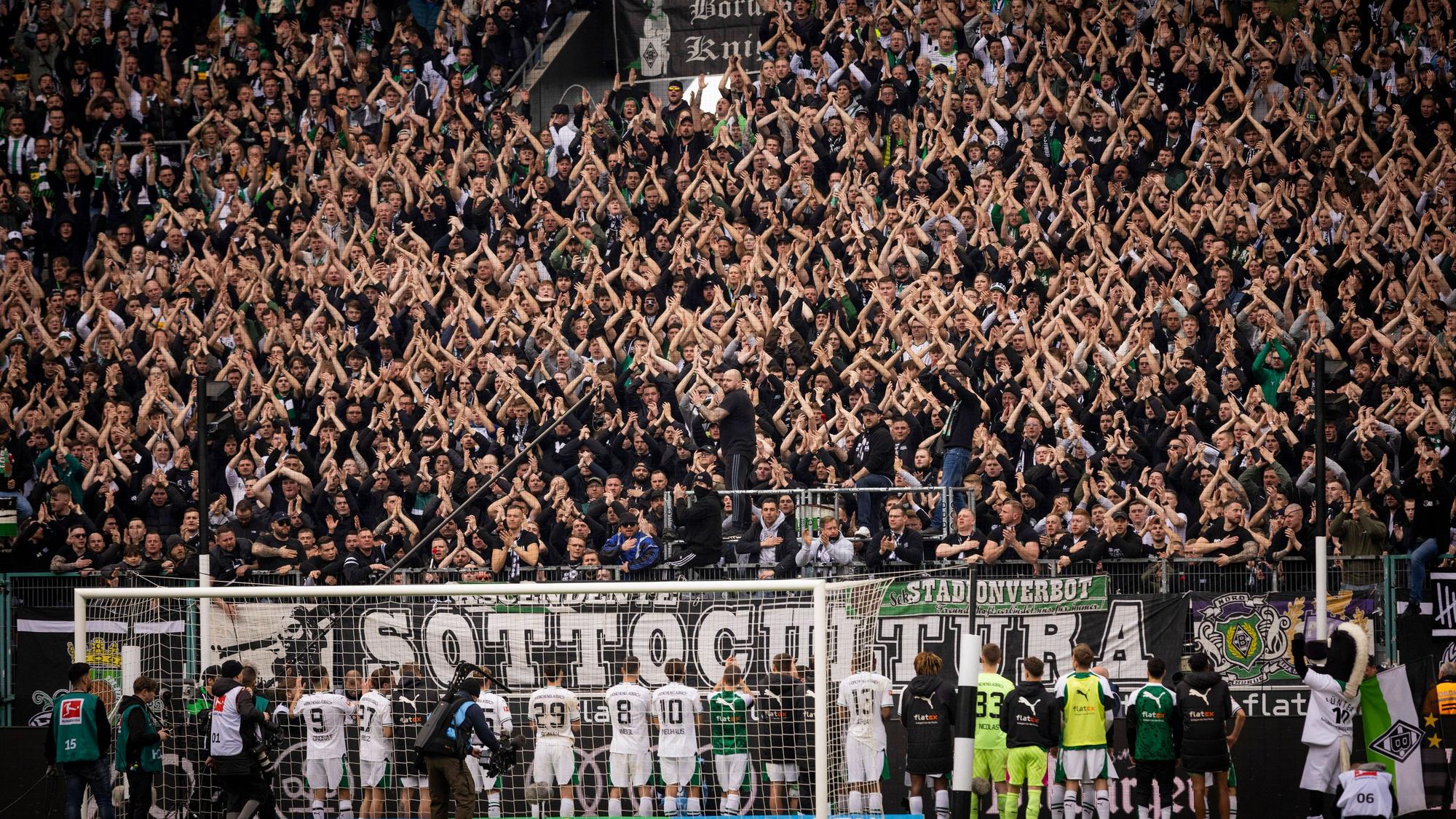 Die Fans von Borussia Mönchengladbach feiern ihre Mannschaft.