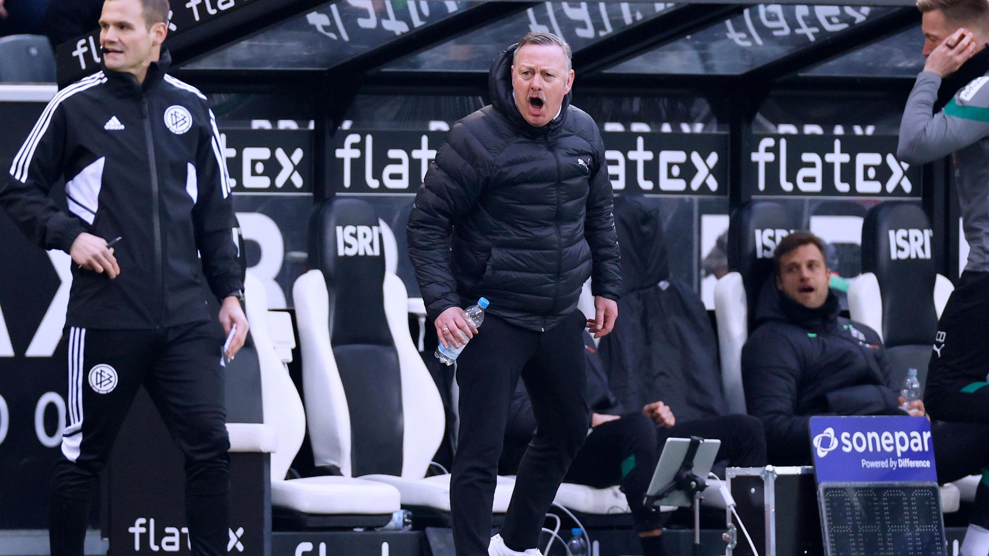 Roland Virkus schreiend vor der Borussia-Bank.