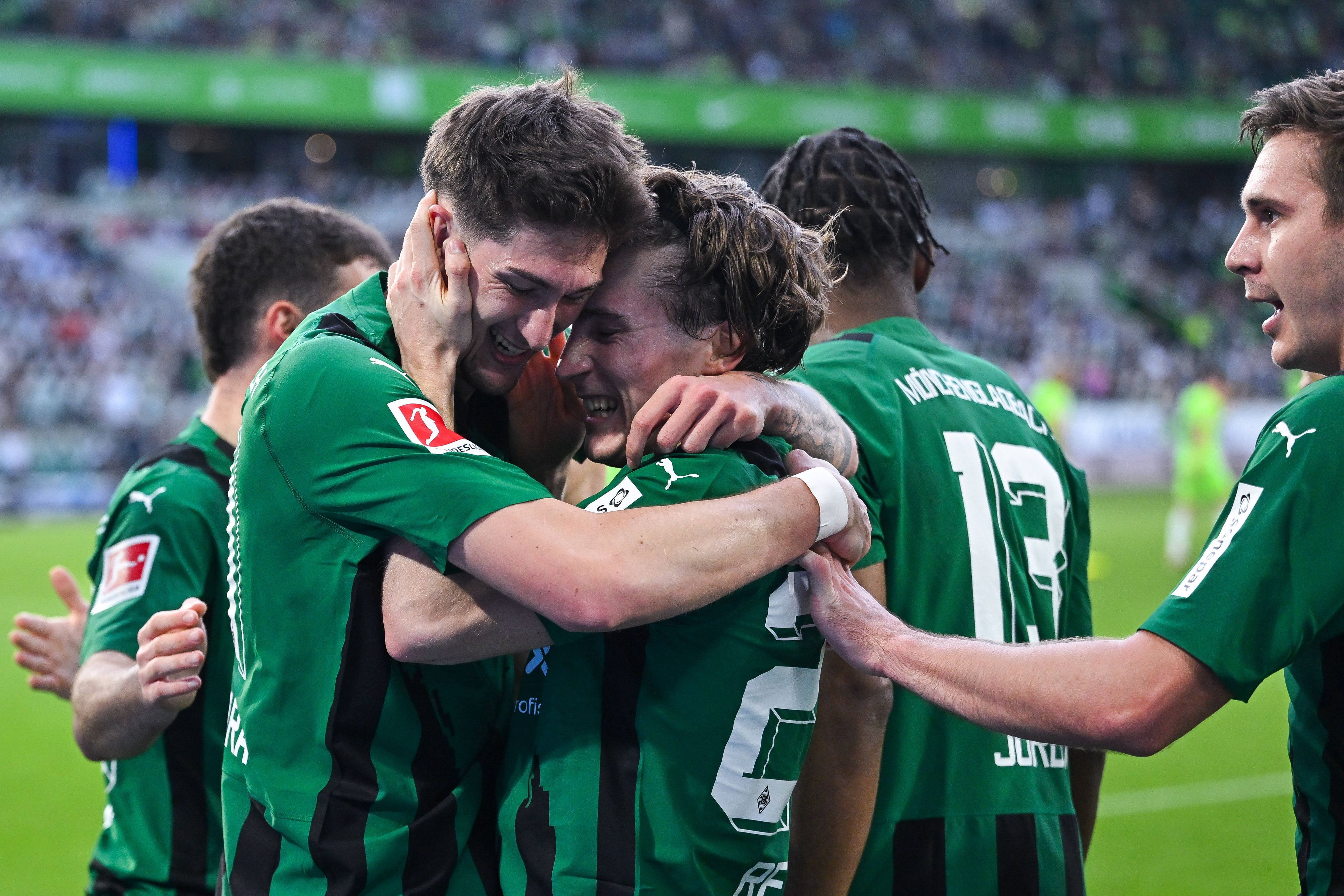 Spieler von Borussia Mönchengladbach freuen sich über einen Treffer und umarmen sich.