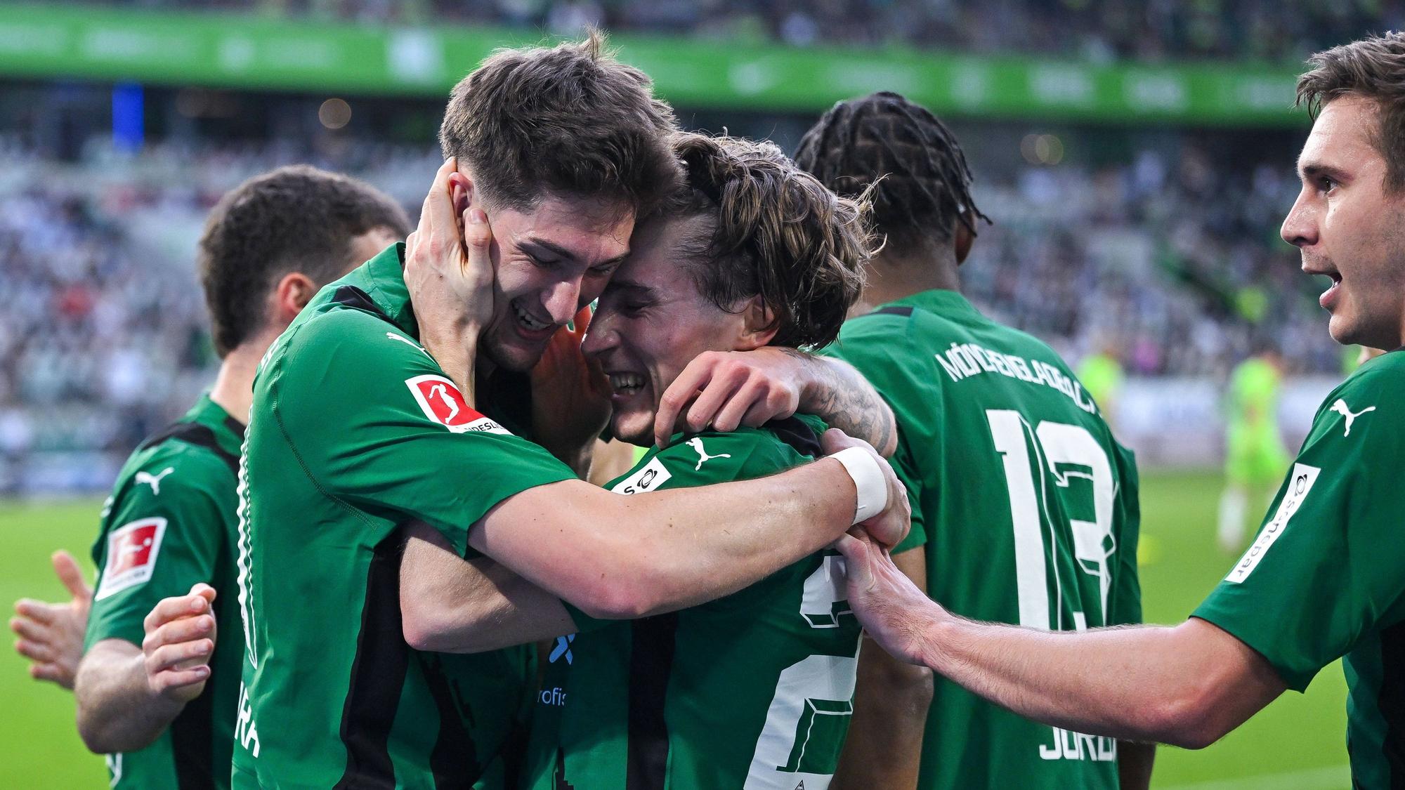 Spieler von Borussia Mönchengladbach freuen sich über einen Treffer und umarmen sich.