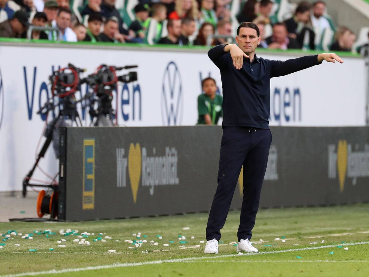 Trainer von Borussia Mönchengladbach mit Armbewegungen an der Seitenlinie.