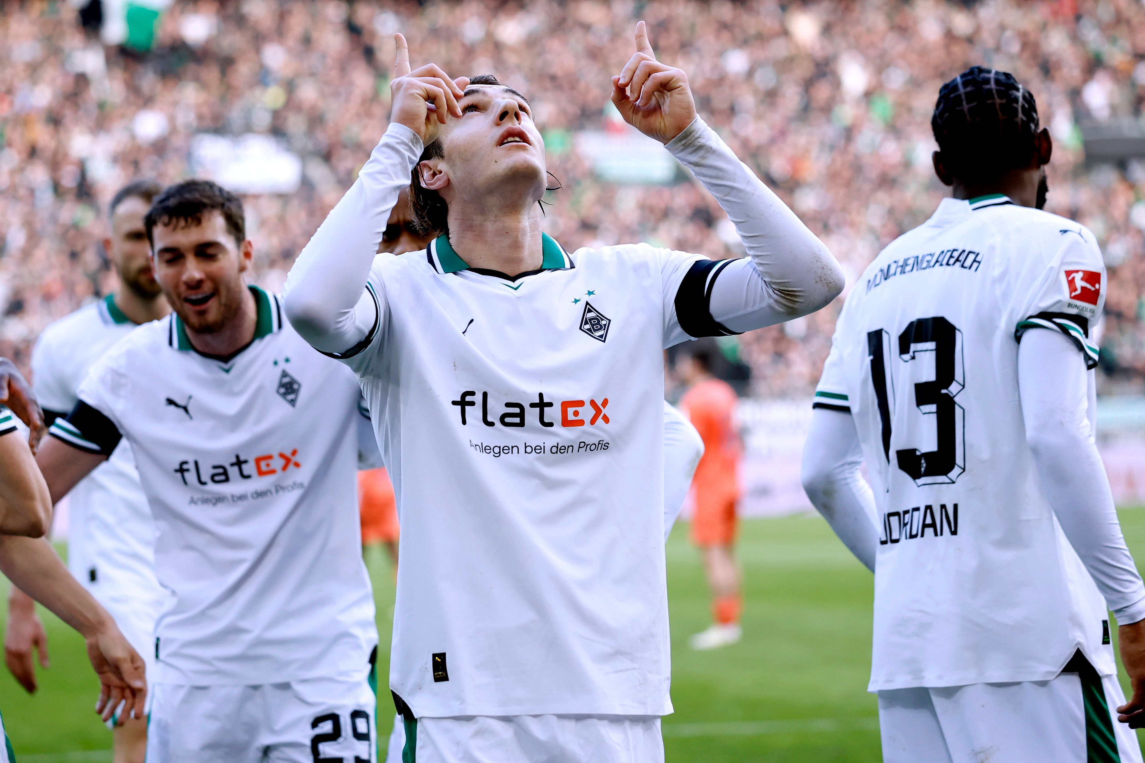 Florian Neuhaus zeigt in den Himmel.