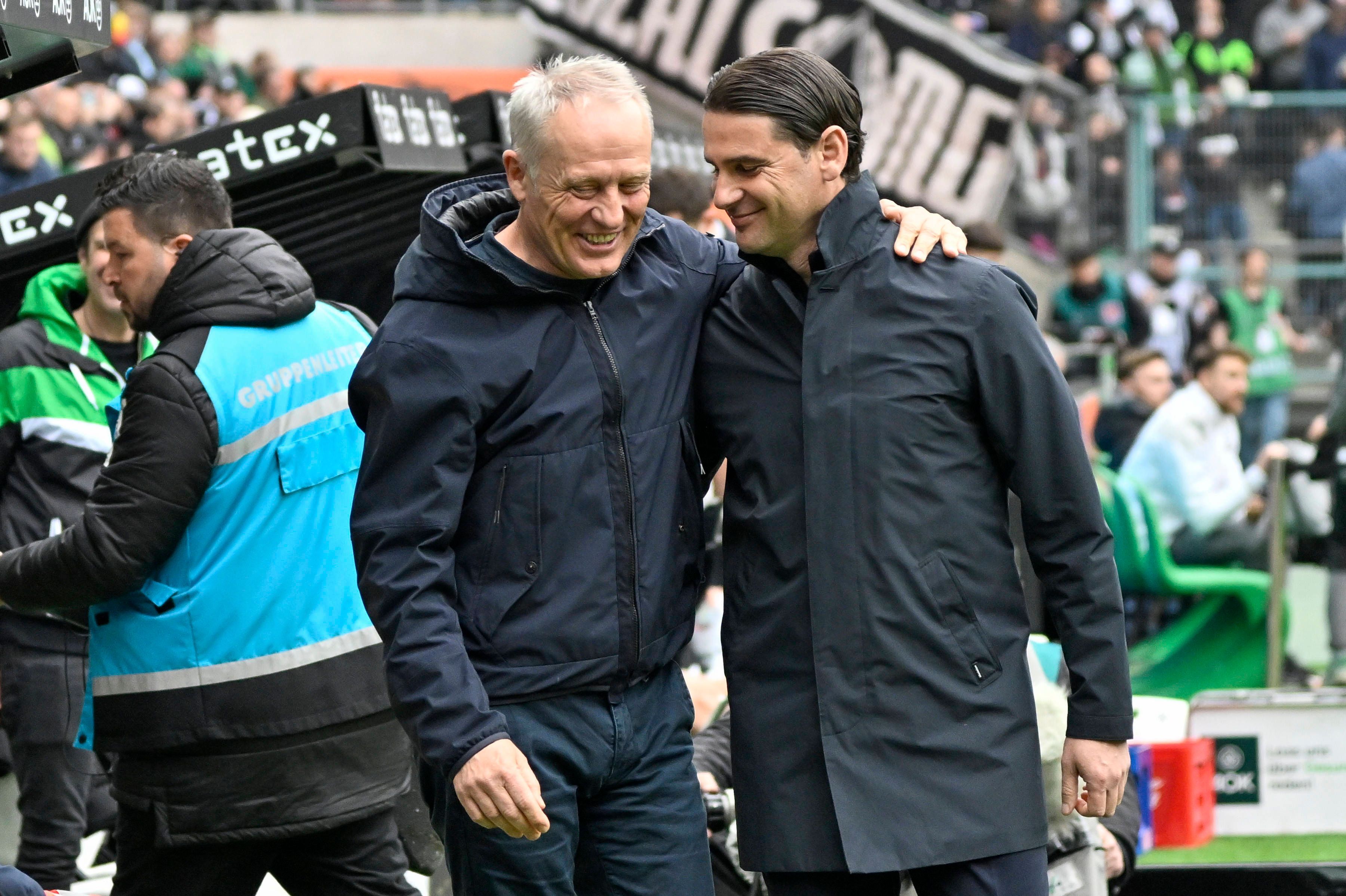 Christian Streich und Gerardo Seoane lächeln und legen die Arme umeinander.