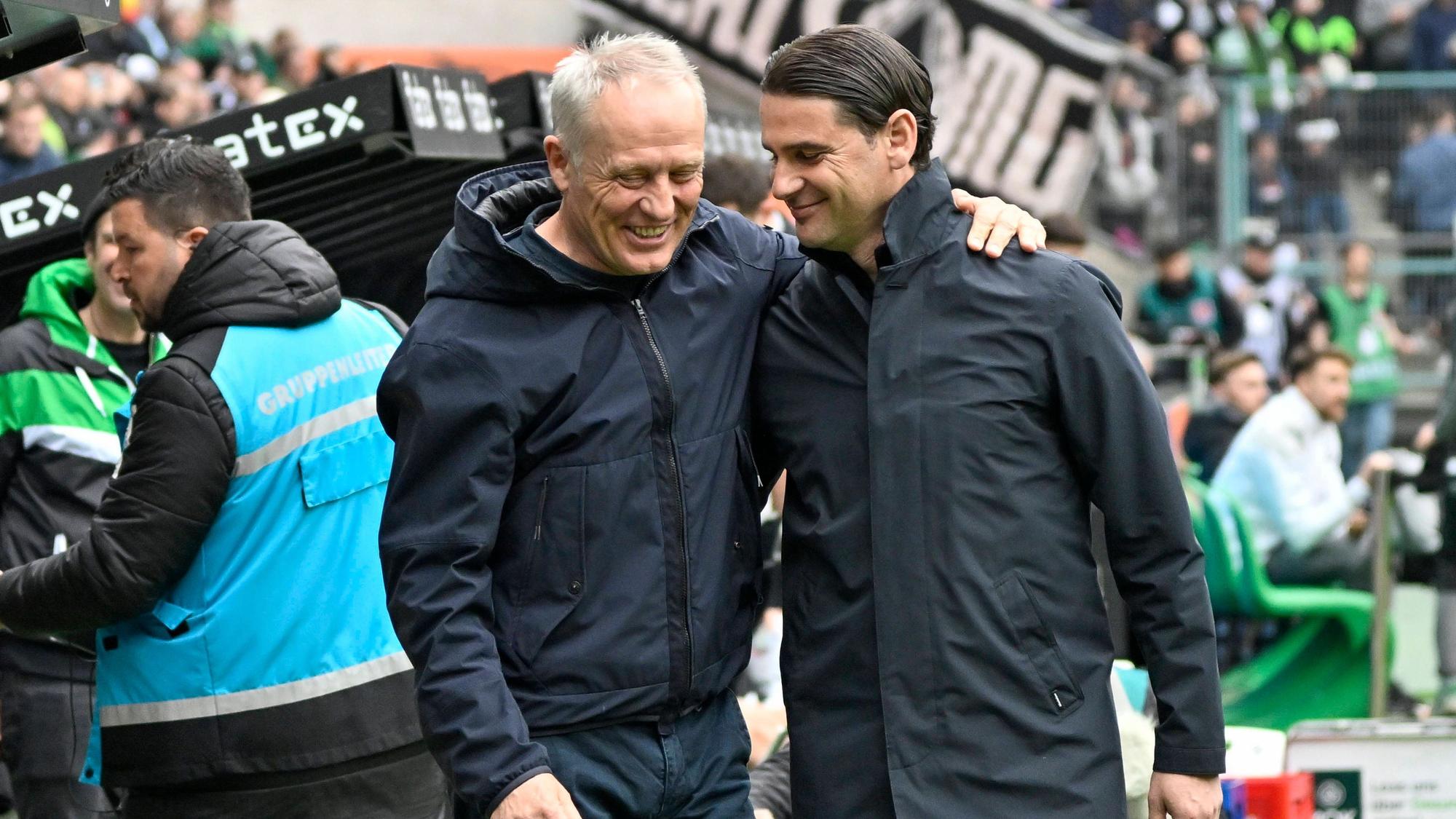 Christian Streich und Gerardo Seoane lächeln und legen die Arme umeinander.