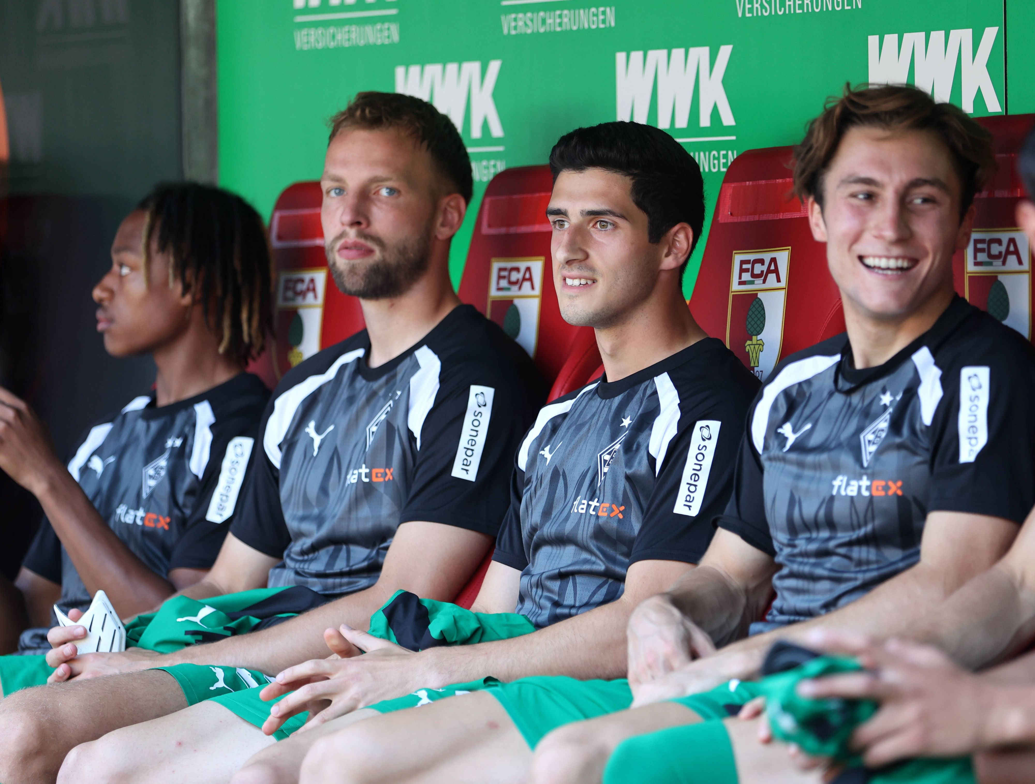 Vier Borussia-Spieler sitzen auf der Augsburger Auswechselbank.