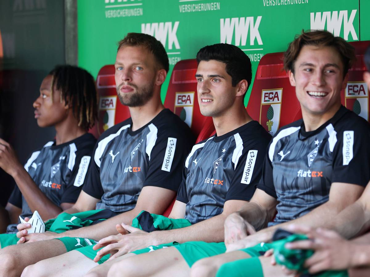 Vier Borussia-Spieler sitzen auf der Augsburger Auswechselbank.