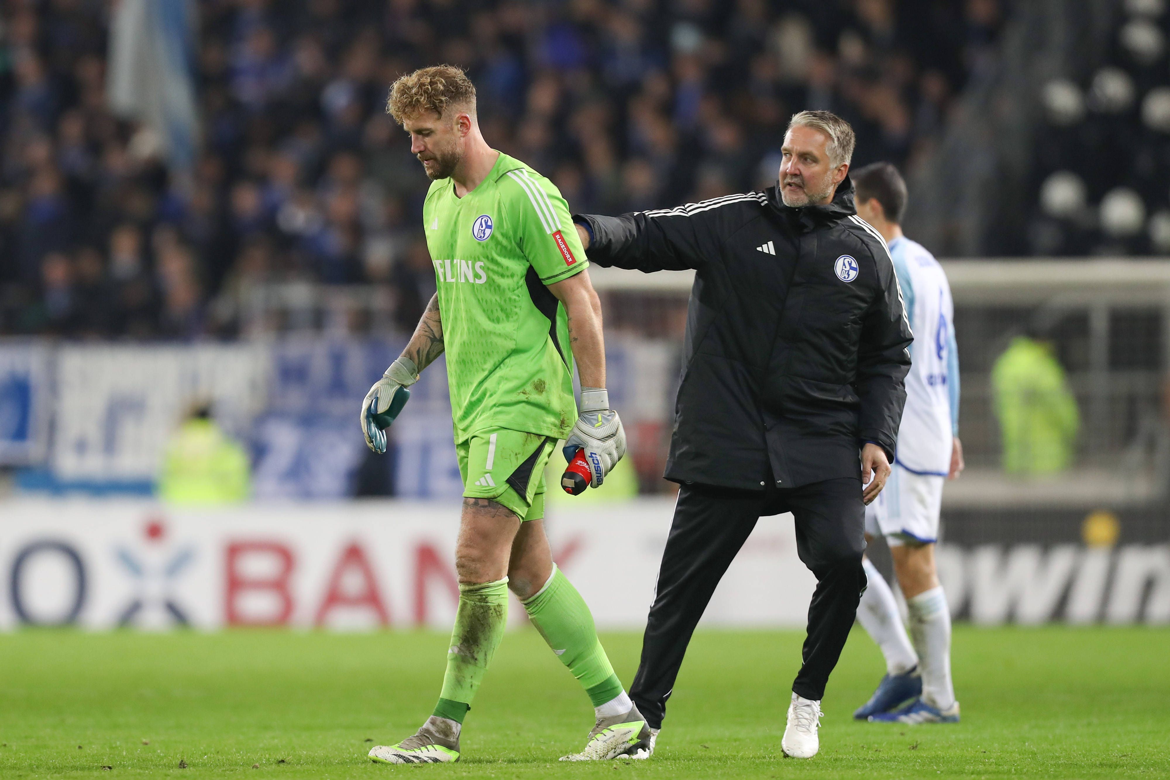 Simon Henzler schlägt Ralf Fährmann auf den Rücken.