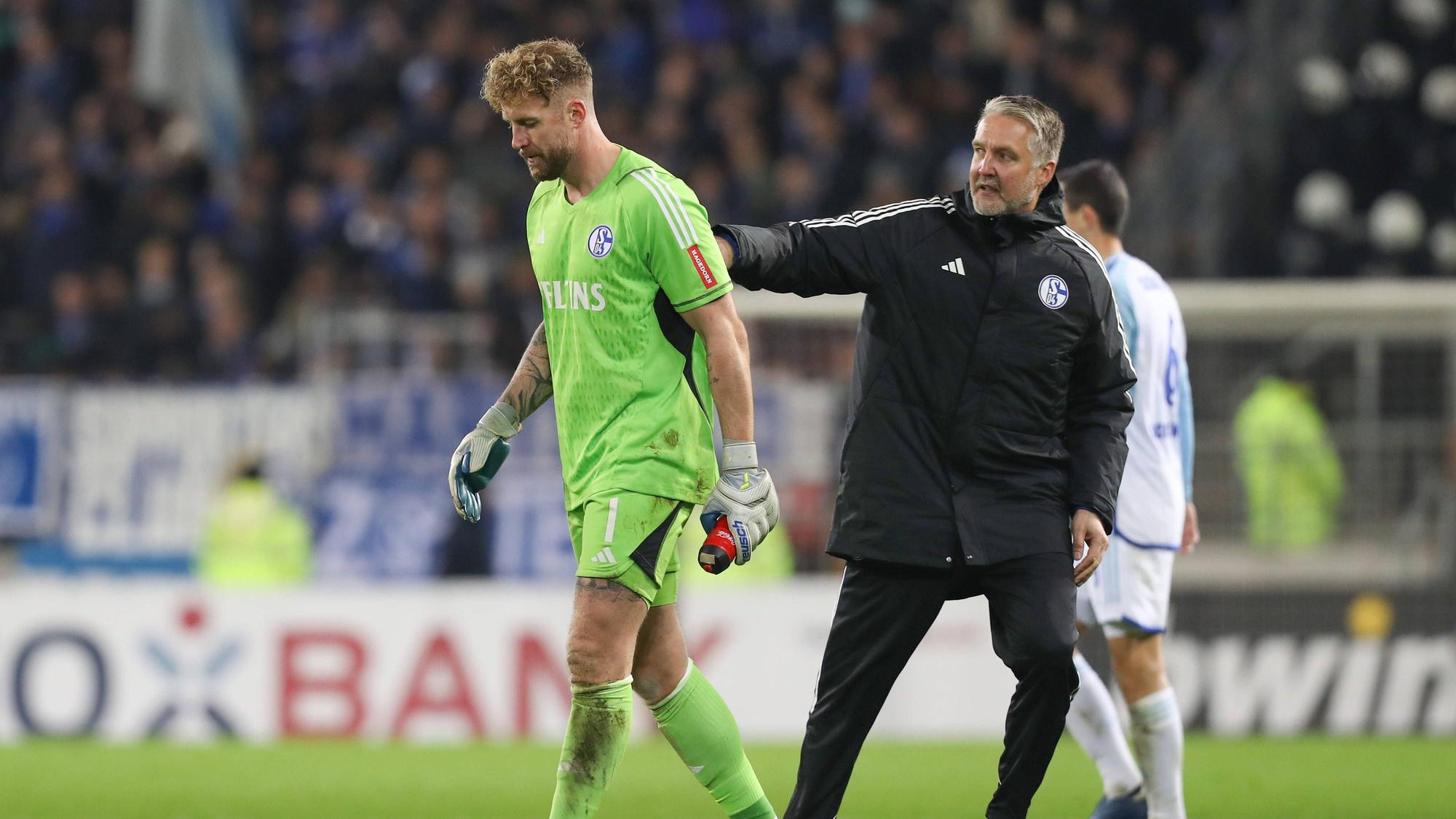 Simon Henzler schlägt Ralf Fährmann auf den Rücken.
