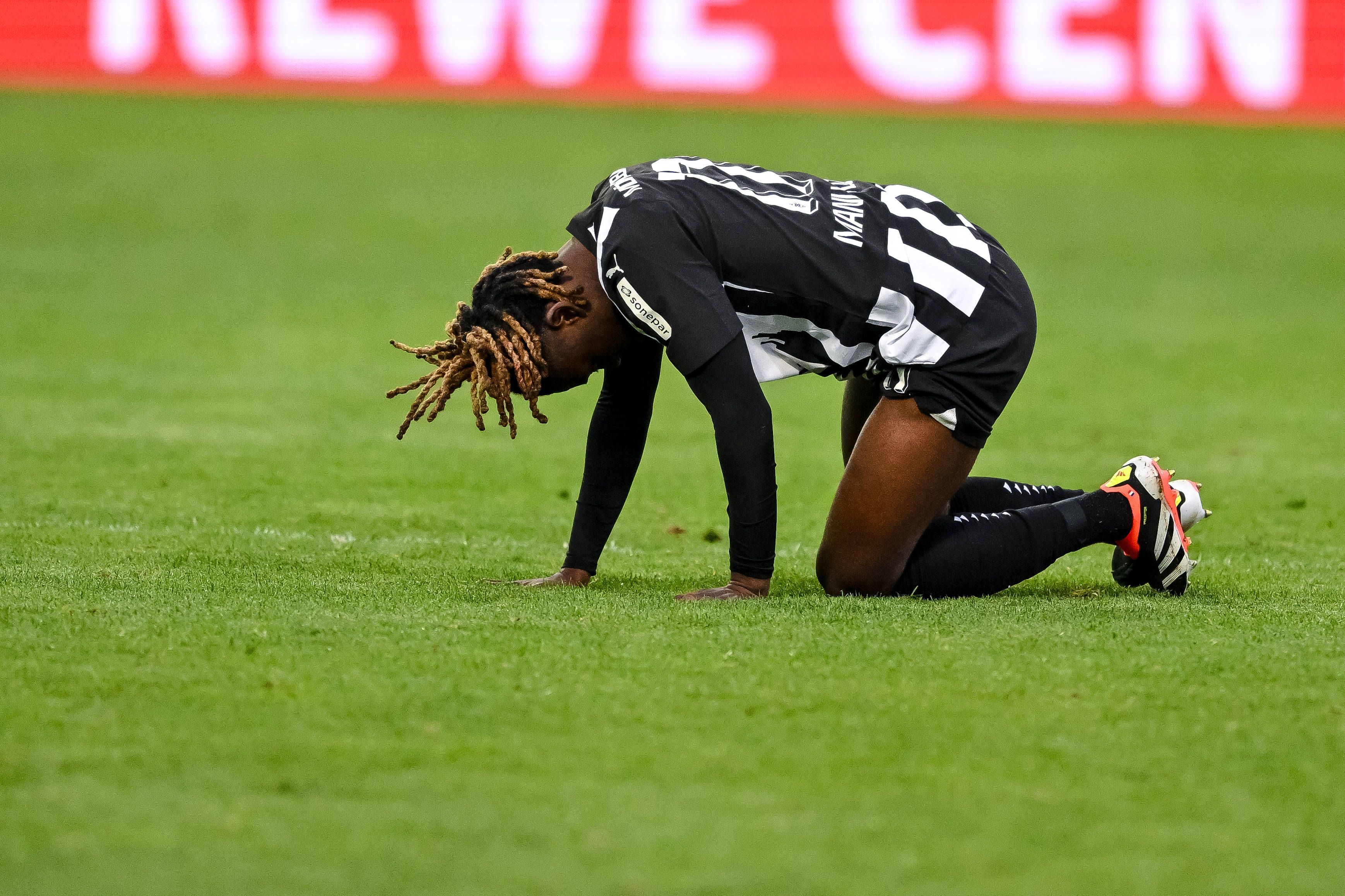 Manu Koné krümmt sich auf dem Rasen.