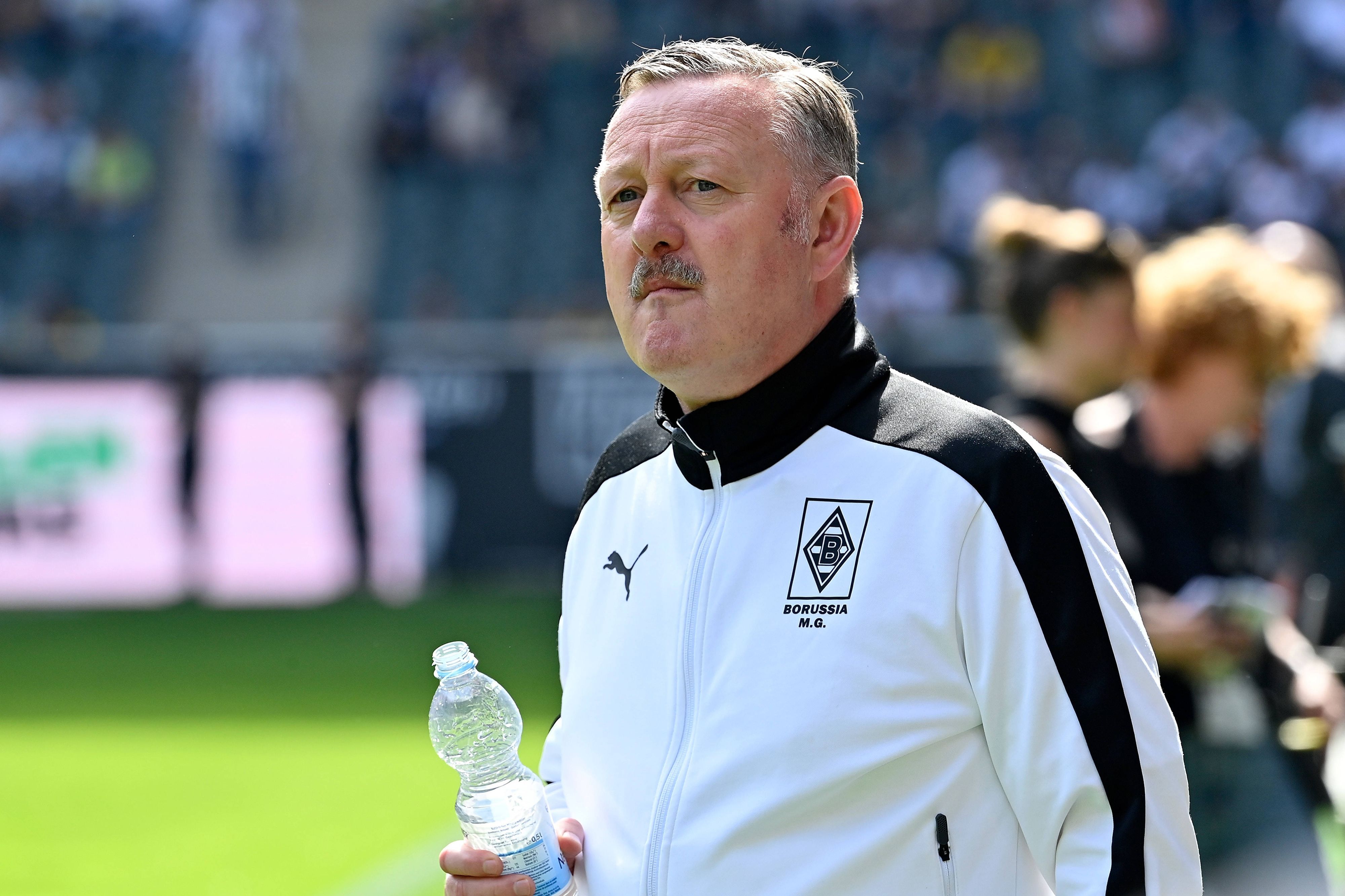 Sport-Chef von Borussia Mönchengladbach mit einer Wasserflasche in der Hand.