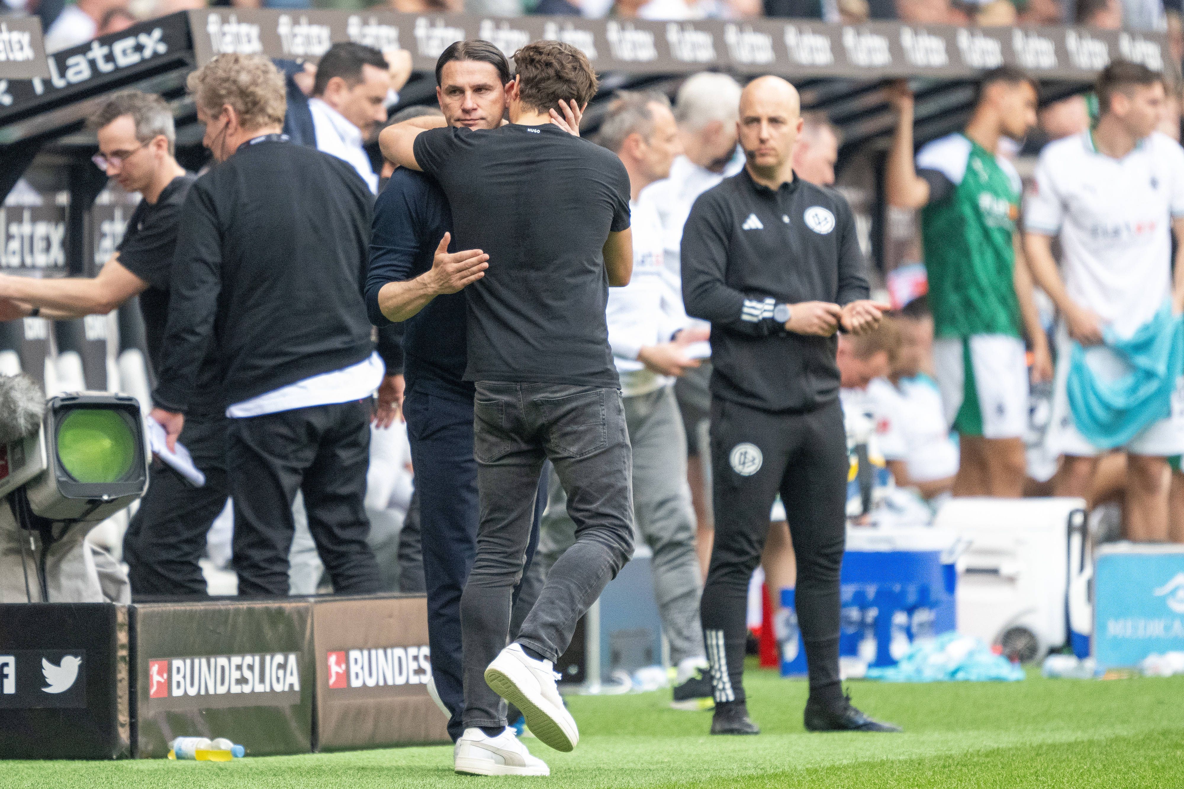 Trainer von Borussia Mönchengladbach und Trainer von Borussia Dortmund ligen sich in den Armen.