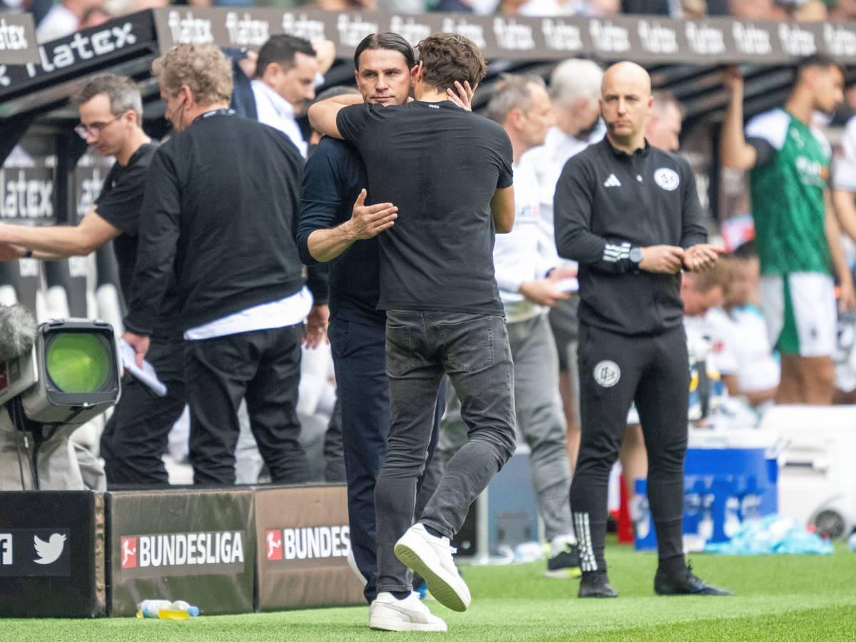 Trainer von Borussia Mönchengladbach und Trainer von Borussia Dortmund ligen sich in den Armen.
