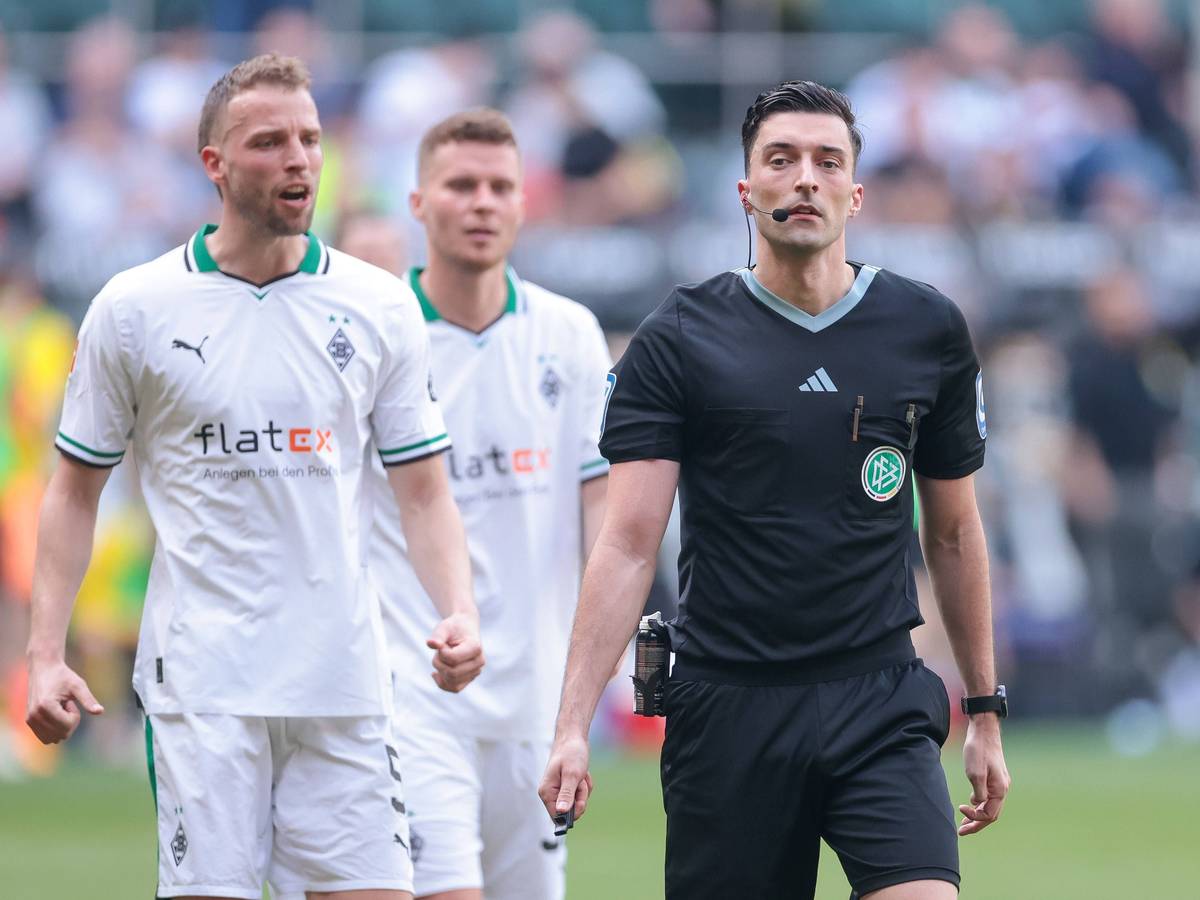Schiedsrichter bei einem Spiel von Borussia Mönchengladbach. Im Hintergrund Marvin Friedrich und Nico Elvedi.