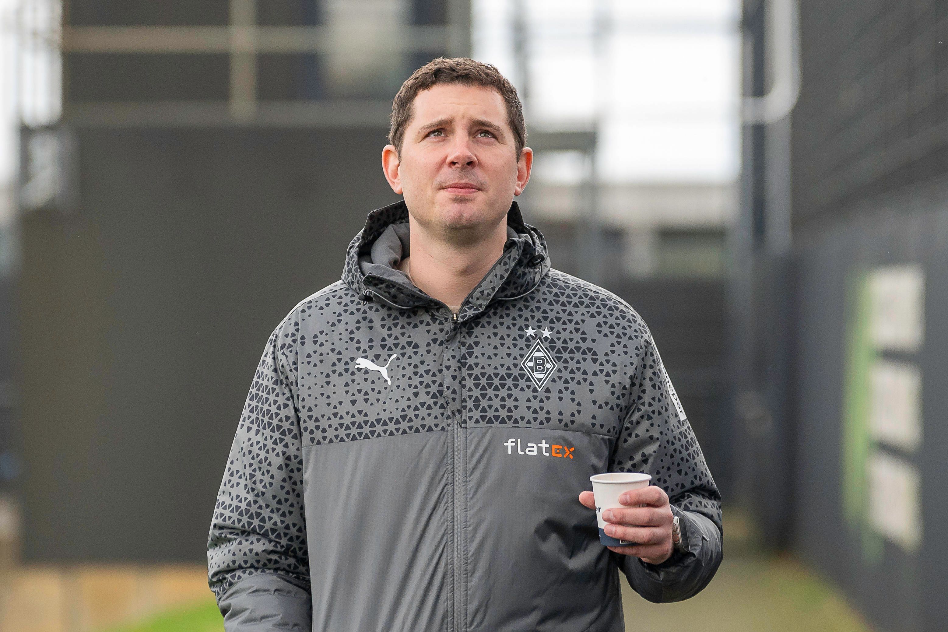Sportdirektor von Borussia Mönchengladbach mit einem Kaffee in der Hand.