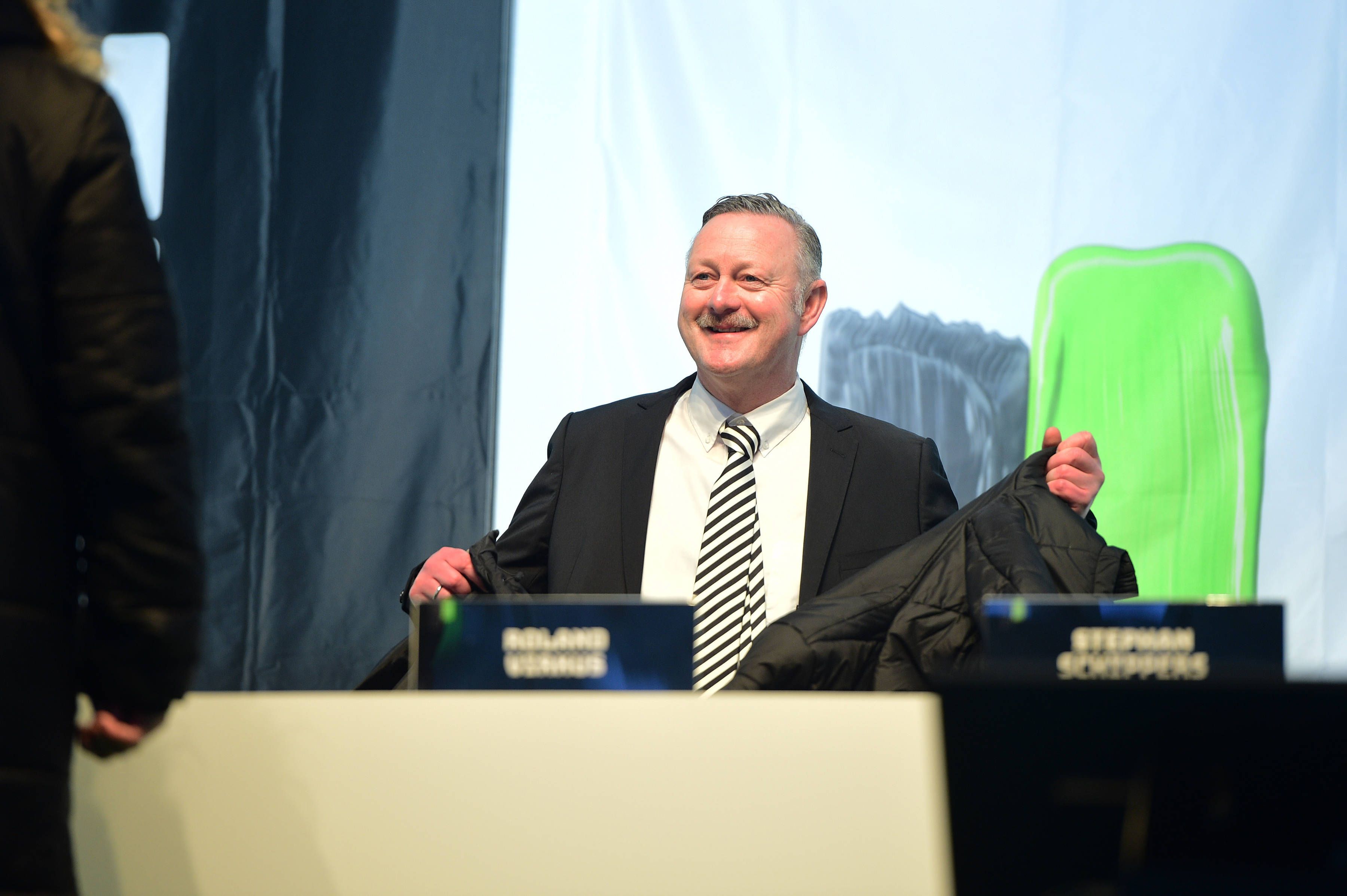 Roland Virkus lächelt auf dem Podium.