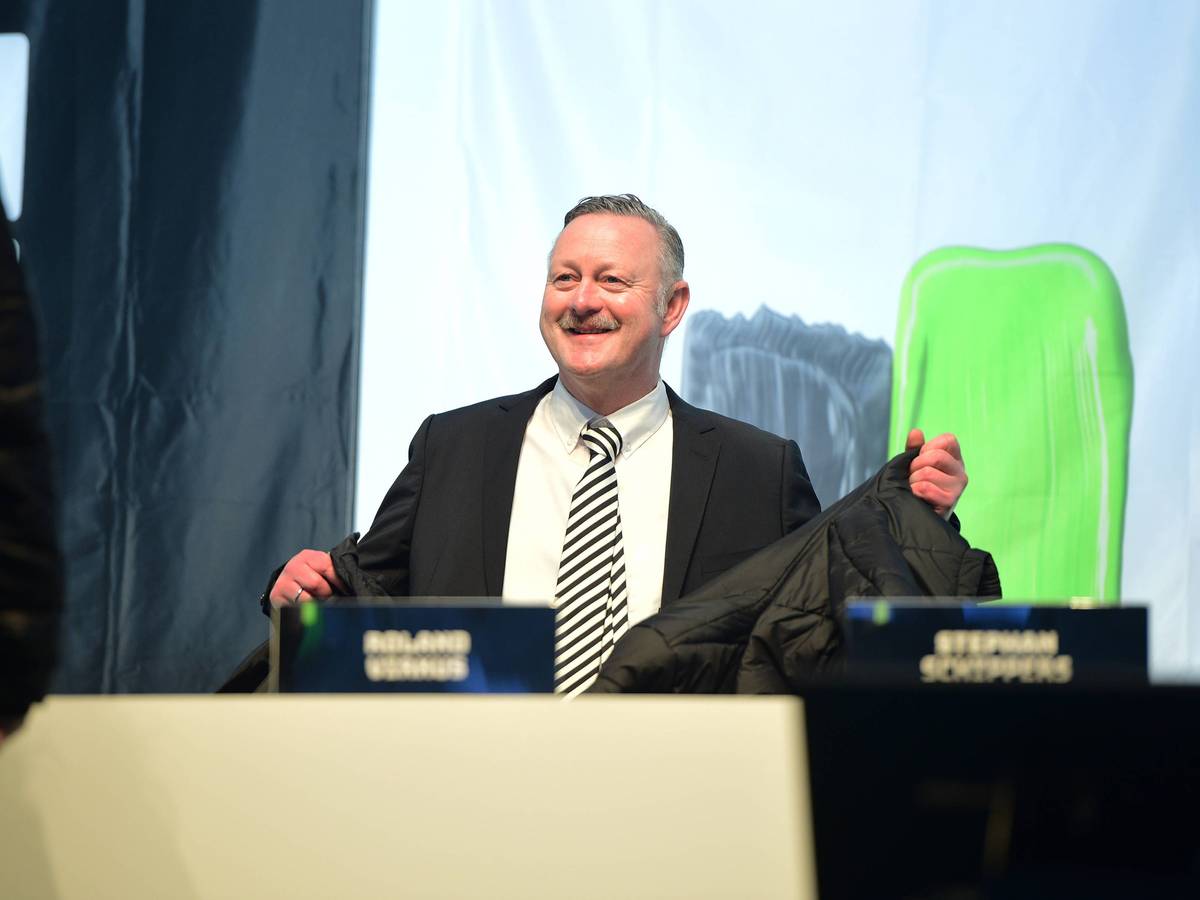 Roland Virkus lächelt auf dem Podium.