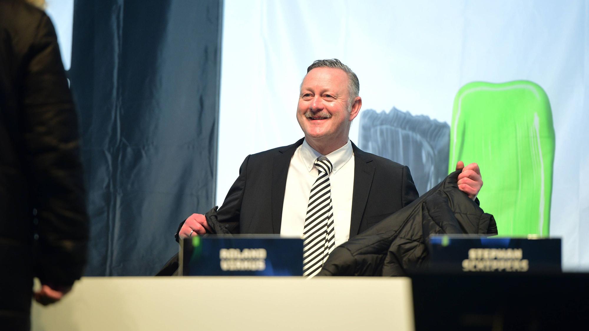 Roland Virkus lächelt auf dem Podium.